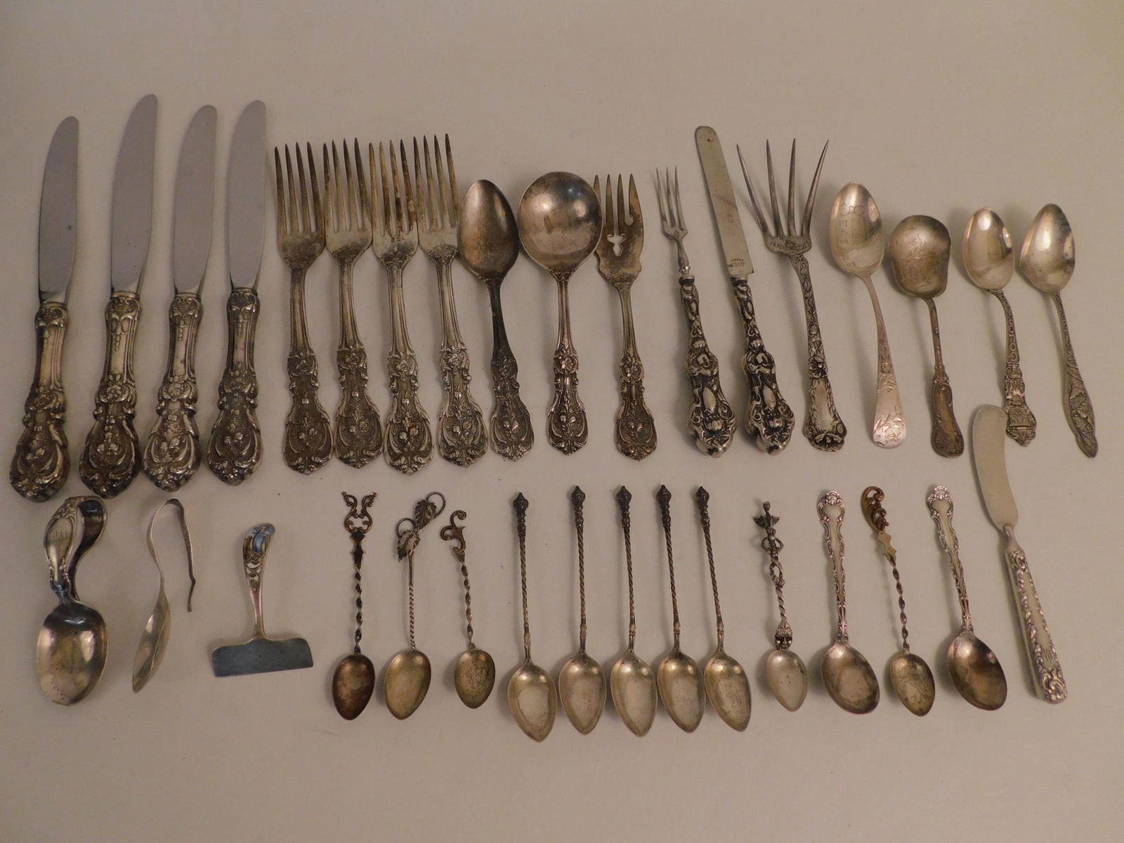34 PIECES STERLING FLATWARE: Lot 34 pieces assorted sterling silver flatware including 11 pieces of Reed and Barton Francis 1st pattern; baby spoons; 5 souvenir spoons; fancy serving pieces; enameled shovel with little boy. Total