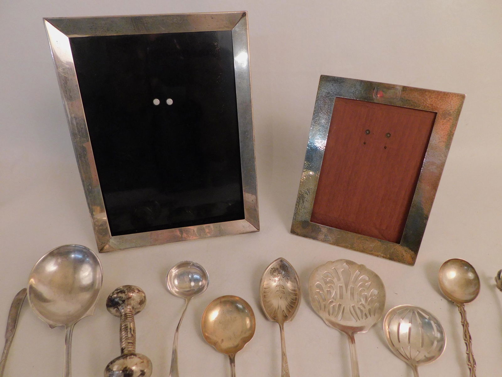 SILVER LOT INCLUDING TIFFANY FRAME: Lot of sterling silver items including 2 picture frames, one stamped Tiffany & Co and is 7 x 5.5 inches & larger signed Black, Starr and Frost Hand Made 9 x 7 inches; 2 pairs of tongs; 6 serving piece