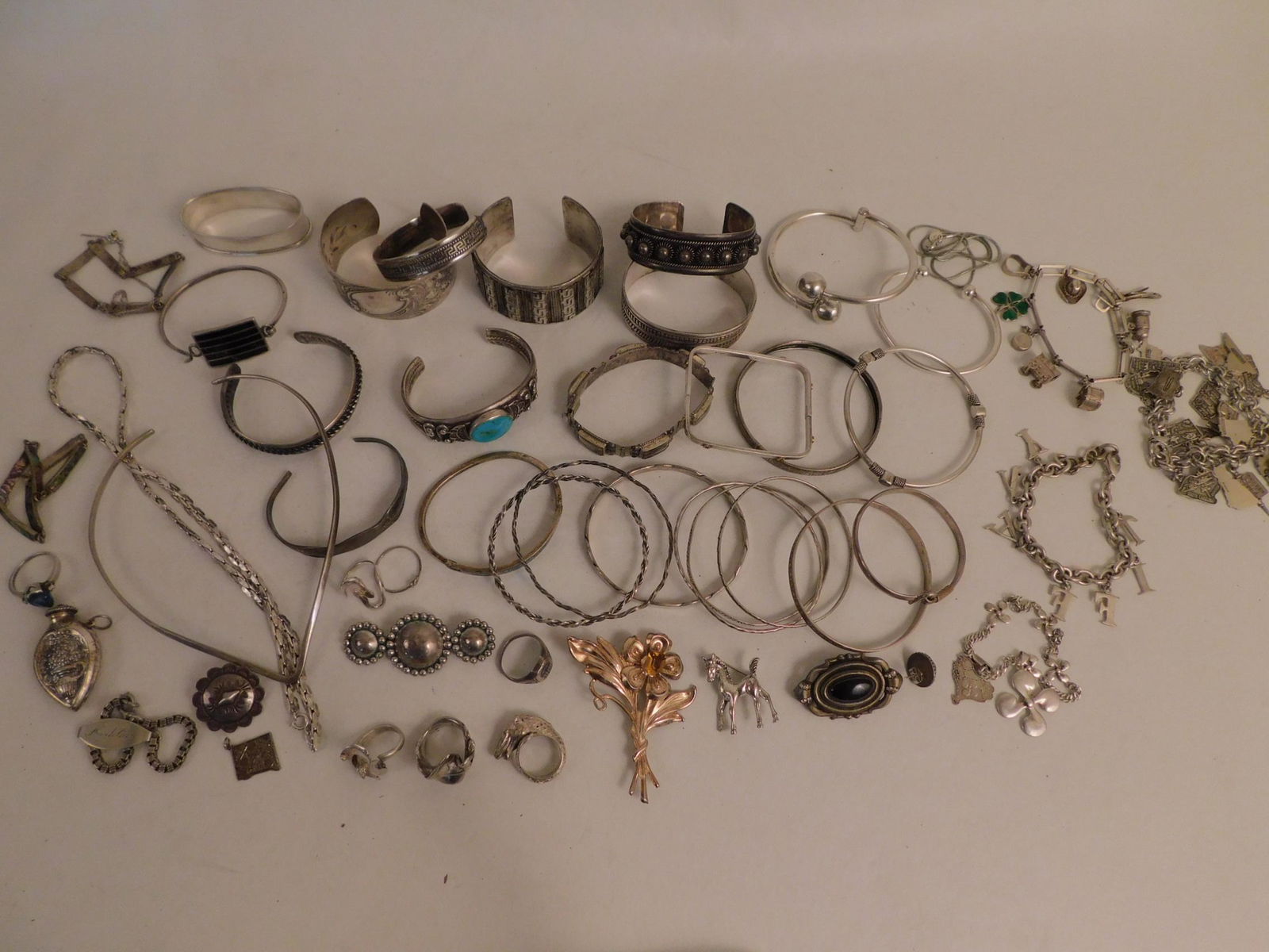 LOT SILVER JEWELRY & CHARM BRACELETS: Lot of sterling silver jewelry: 4 charm bracelets including Tiffany, various states of US; many bracelets including Mexican; necklaces, rings, brooches, .800 Greek silver cuff bracelet, triple ball br