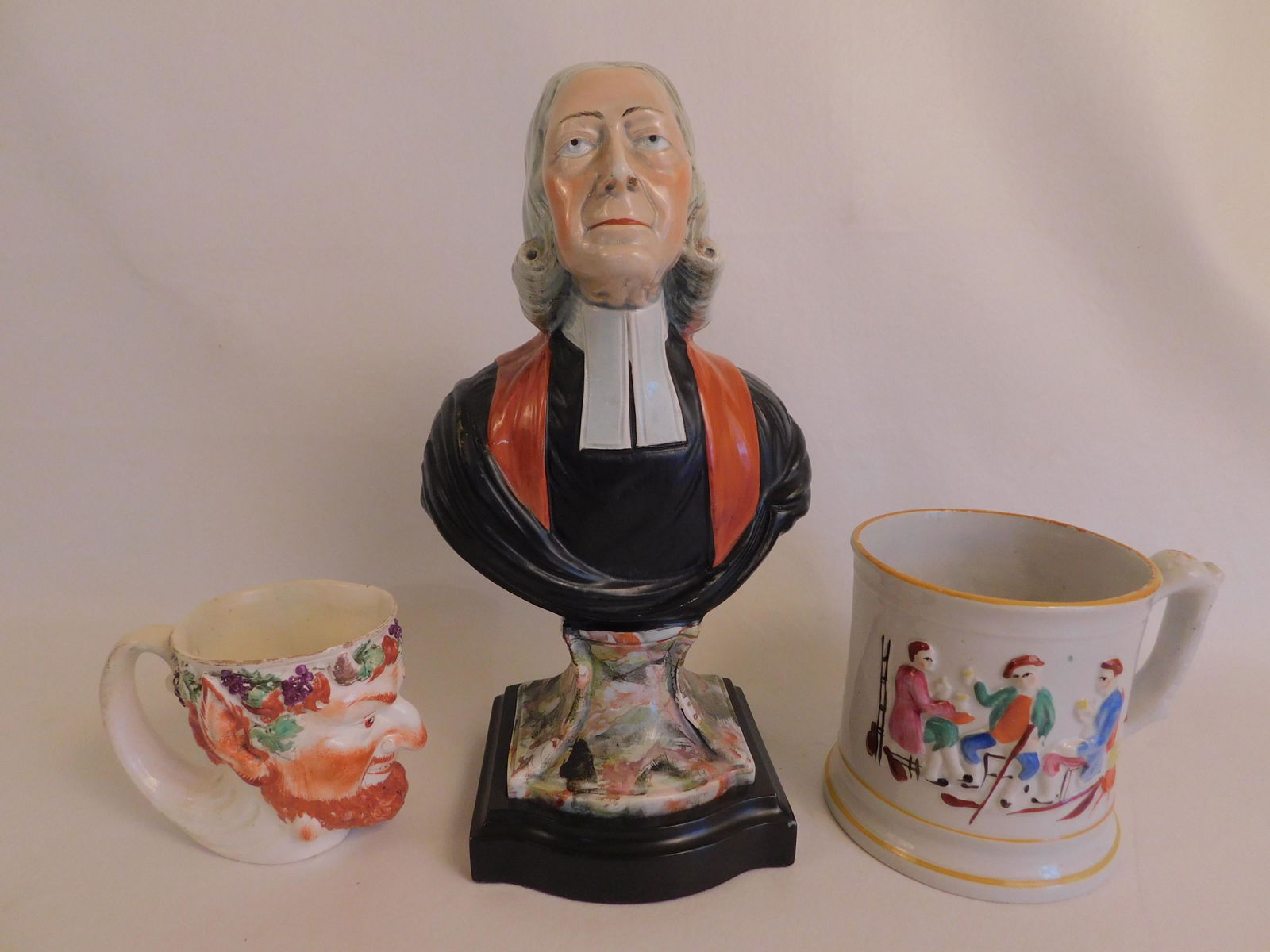STAFFORDSHIRE JOHN WESLEY BUST & MUGS: Lot of 3 early 19th century English ceramics: A Staffordshire bust by Enoch Wood of Rev. John Wesley circa 1800, 12 in tall on wood base; Large Staffordshire mug with embossed figures and frog interio