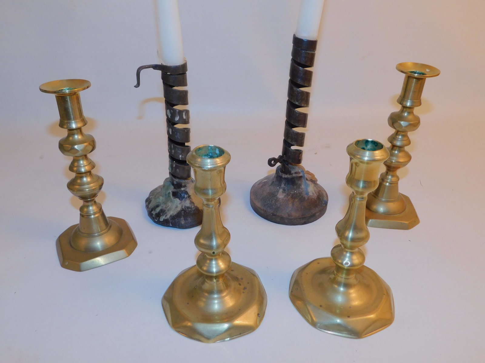 LOT EARLY CANDLESTICK HOLDERS - IRON SPIRAL & BRASS: Lot of 3 pairs of 18th/early 19th century candlesticks: pair of iron twist screw-up with wood base; Queen Ann brass; and circa 1800 beehive top. To 7 inches tall. From the Barbara Almquist estate.