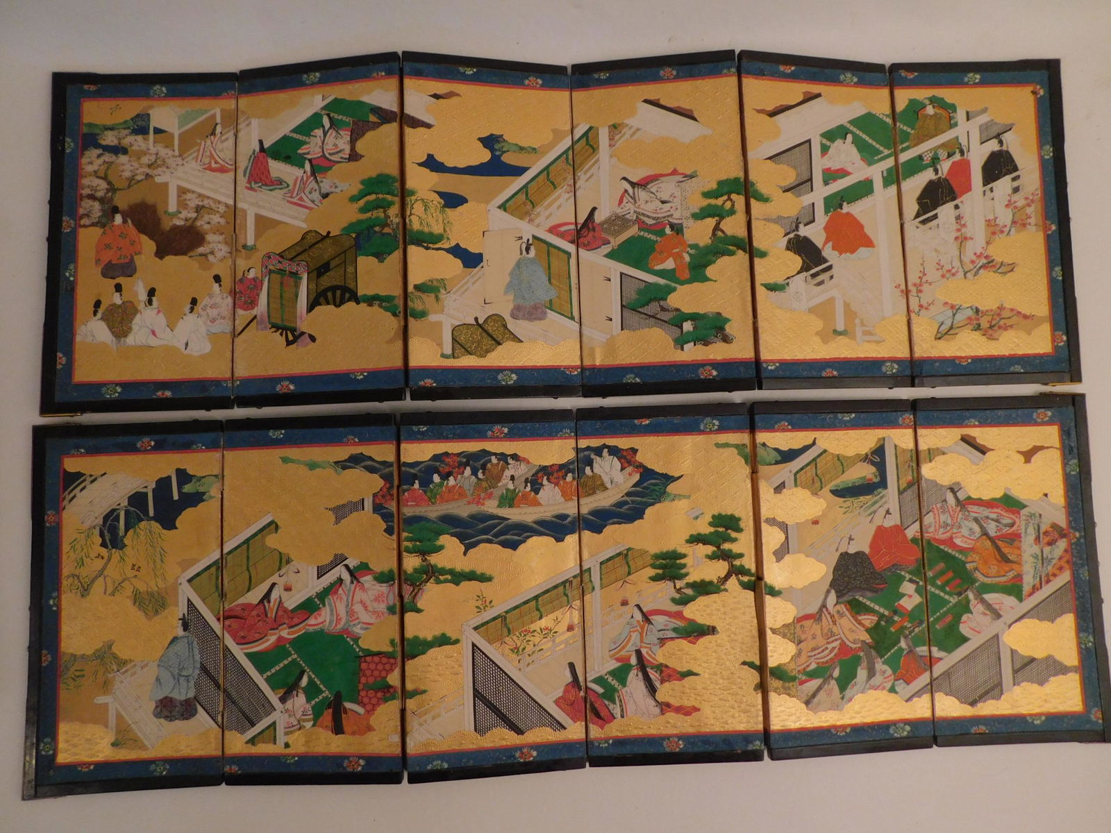 PAIR ANTIQUE JAPANESE TABLE SCREENS: Pair of exquisite 19th century Japanese hand painted and gilt, small folding table screens with many figures in various activities. Each has 6 panels and they stand 8 inches high and 24.5 in long. In