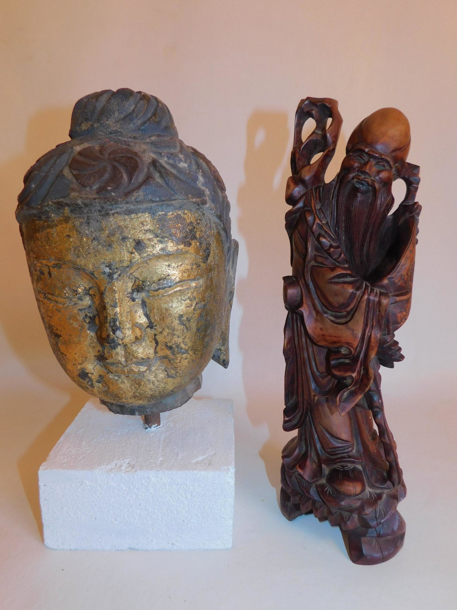 CHINESE STONE BUDDHA & WOOD FIGURE: An antique Chinese stone polychrome buddha head on stone base (repaint) and a carved wood Chinese scholar figure. Sizes to 12 in tall.