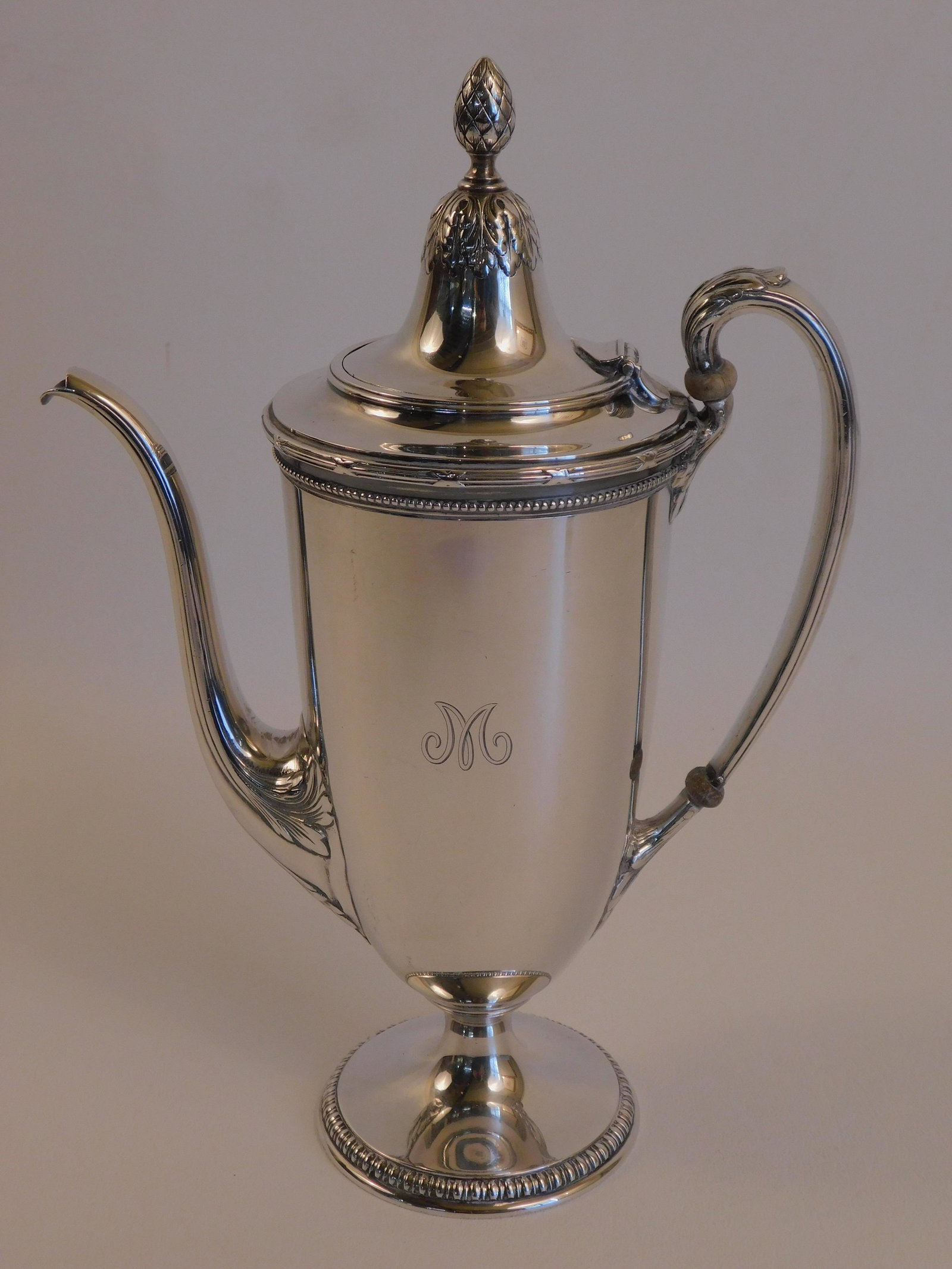TIFFANY & CO. STERLING SILVER TEAPOT: Graceful sterling silver teapot with classical design and beaded trim signed Tiffany & Co. Makers, M director's mark, 4&3/4 Gills, 9.5 inches tall. Has light "M" monogram on one side. Weighs 21.93 ozt