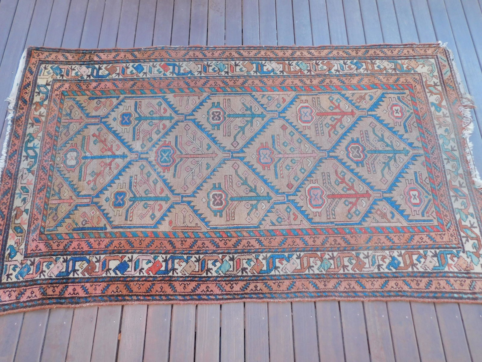 ANTIQUE PERSIAN SCATTER RUG: Antique Persian scatter rug in camel hair color with dark blue zig-zag diamond patter field. 3 ft 6 by 6 feet. Allover light wear, some loss to end.