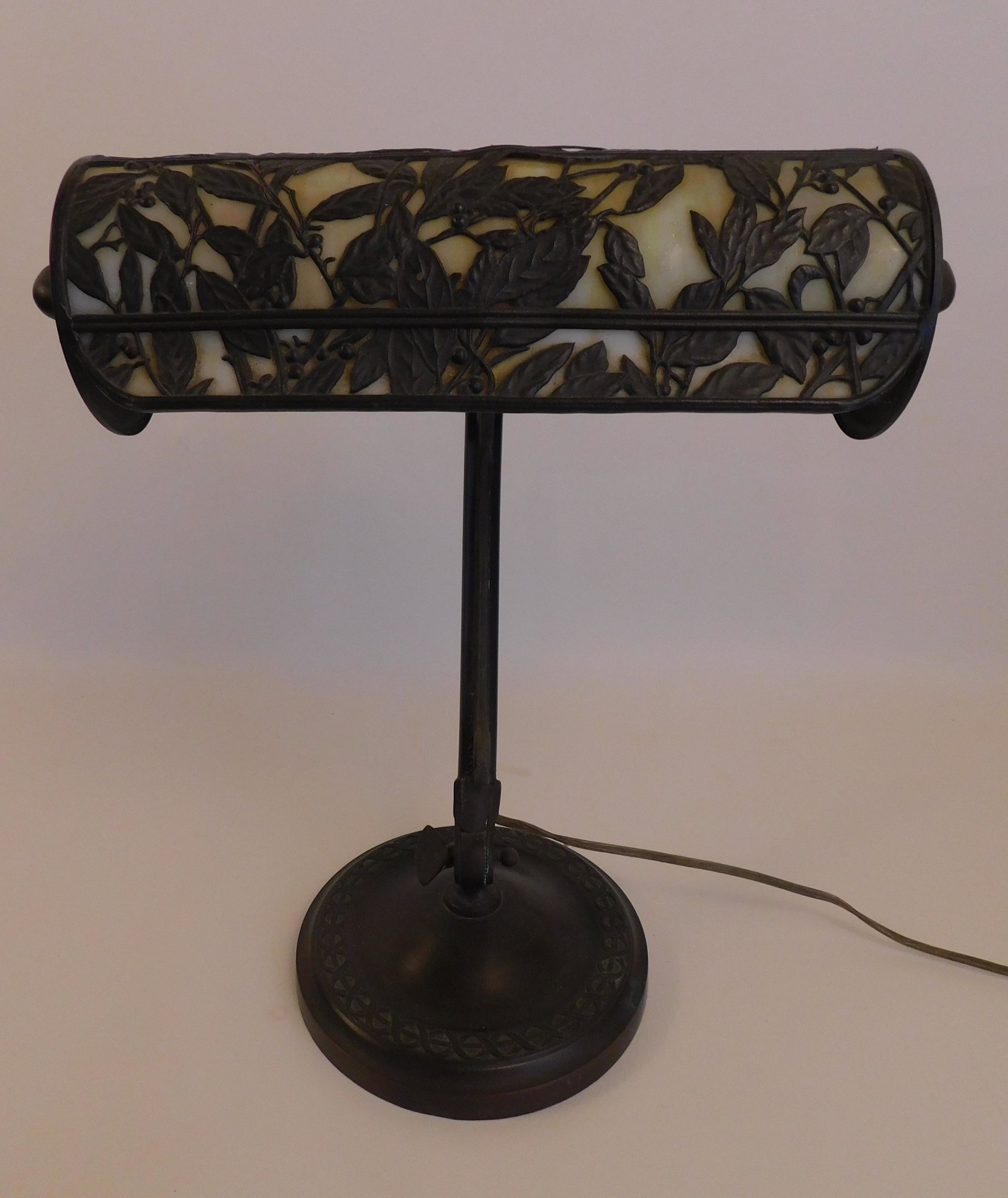HANDEL DESK LAMP: Art Nouveau period goose neck bronze desk lamp with cylindrical butterscotch glass shade with floral overlay signed Handel. 15 in high, shade 10 in wide. VG condition.