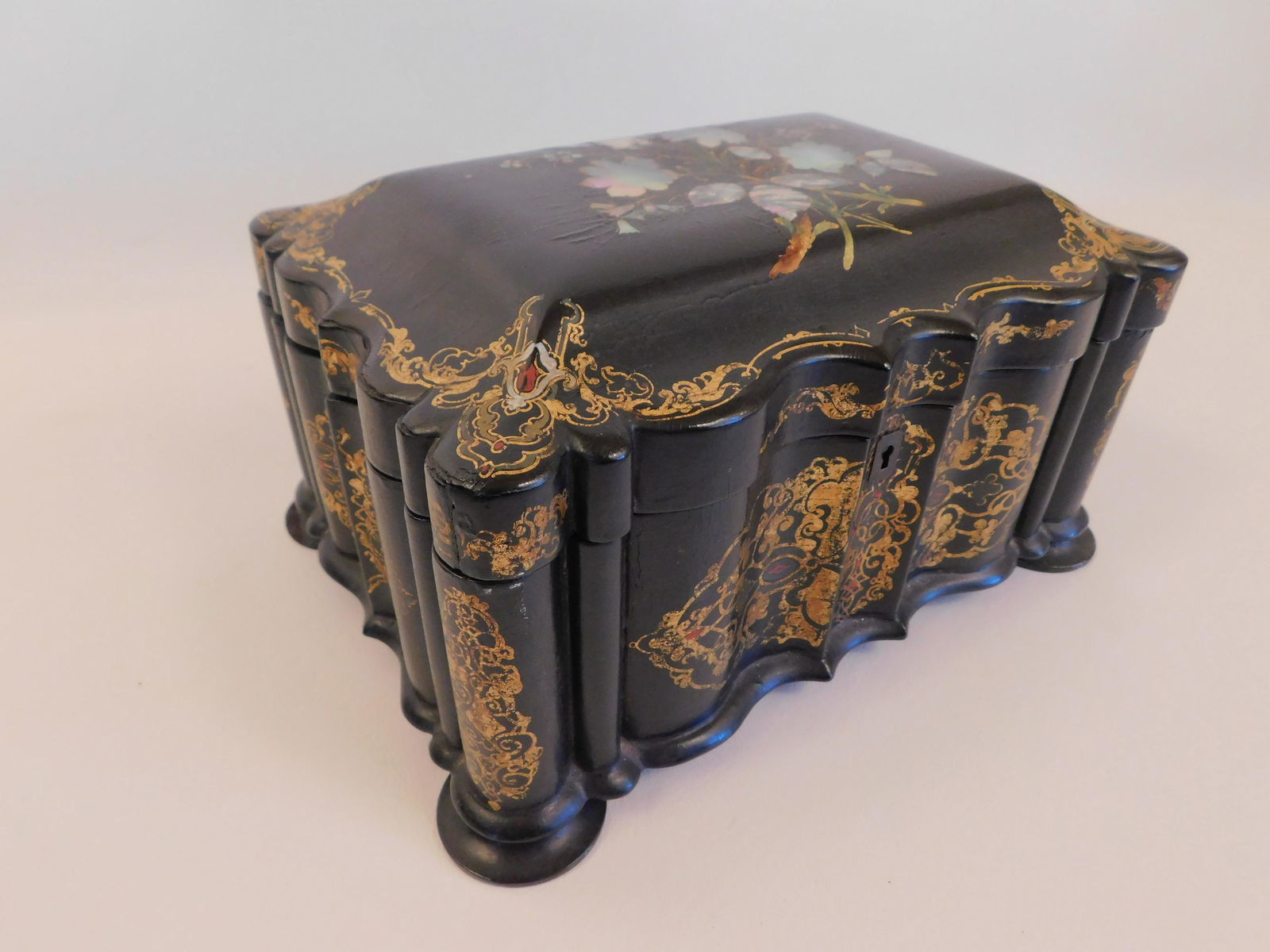 ANTIQUE PAPER MACHIER BOX: Circa 1850 abalone inlaid and gilt paper machier desk box with serpentine shape and floral designs. 10 x 8 x 5.5 inches. One back foot with chips.
