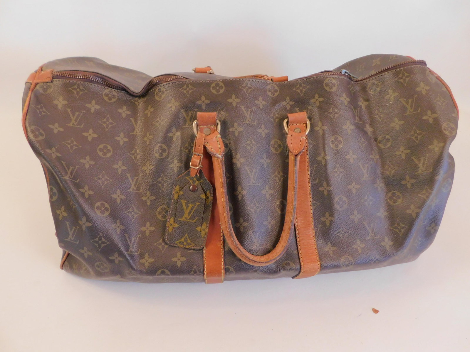 LOUIS VUITTON DUFFEL BAG: Old Louis Vuitton logo duffel bag, wear and discoloration, 21 x 11 inches.