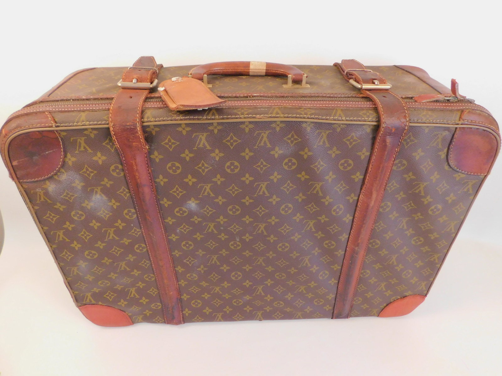 LOUIS VUITTON 27 X 18 INCH SUITCASE: Old Louis Vuitton logo medium sized suitcase, wear/stains. CORRECTION ON SIZE: 27 X 18 INCHES.