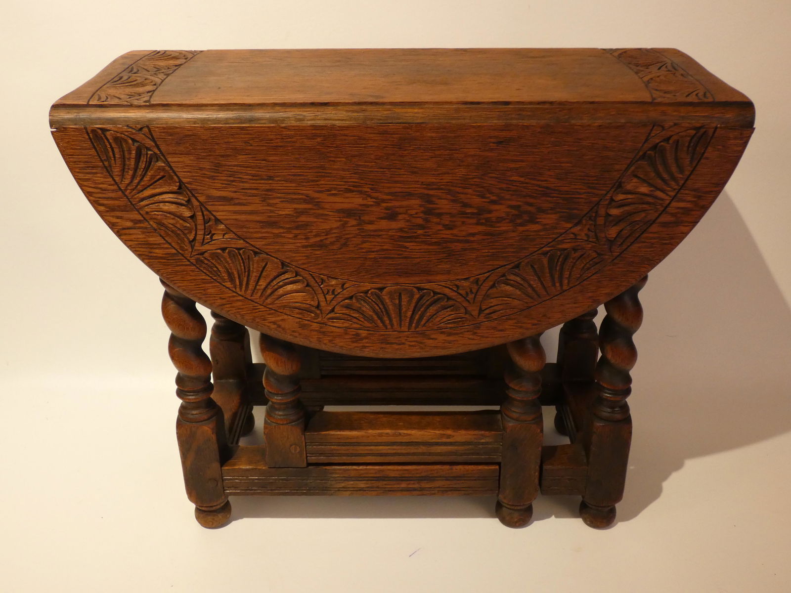 OLD KITTINGER DIMINUTIVE CARVED TABLE: Old solid oak diminutive drop leaf / gateleg type table with carved floral edge and pegged construction. Signed Kittinger with metal label circa 1930's. Size: Open 27 x 23.5 inches, 8.5 inches wide wh