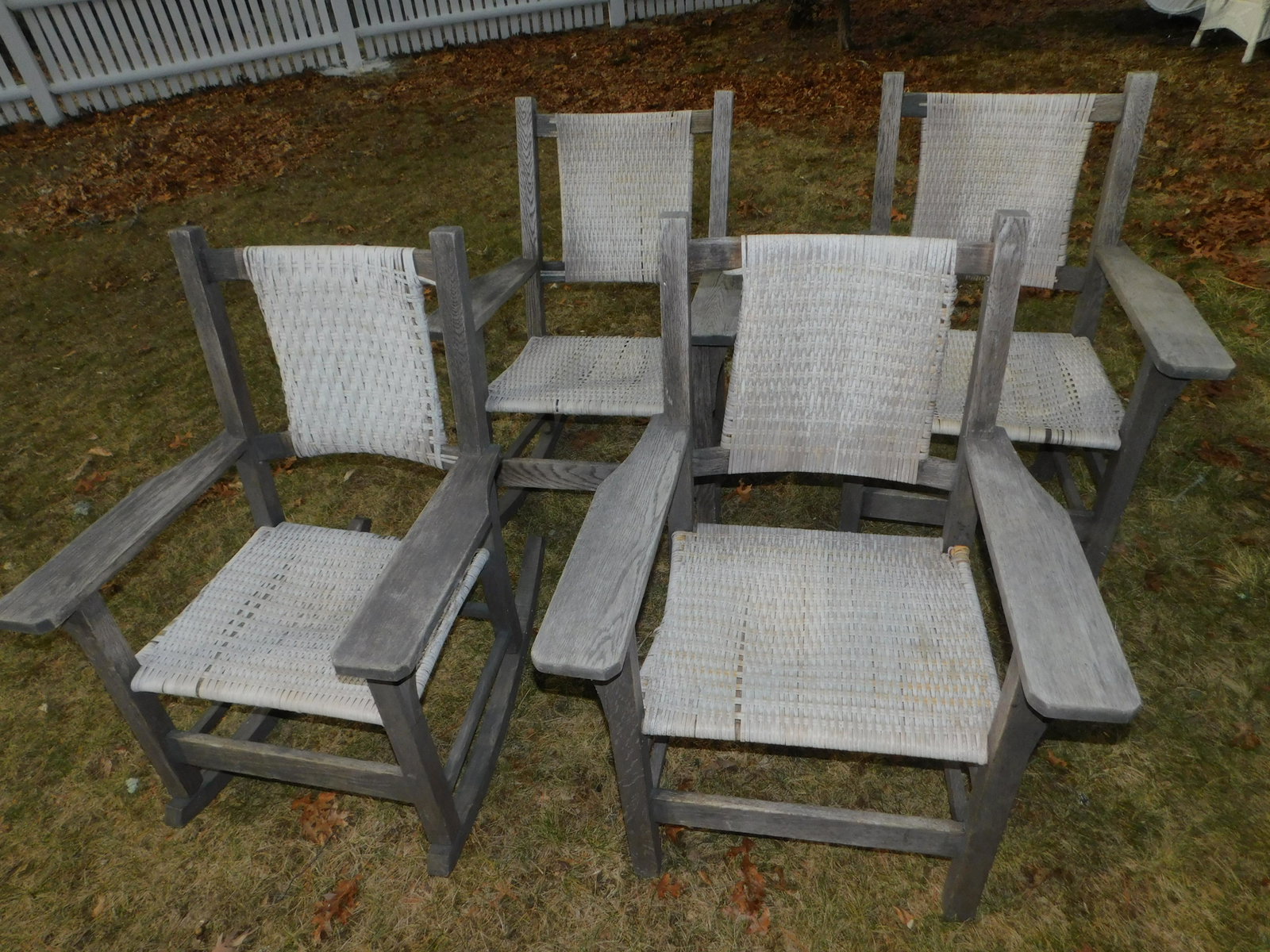 4 WOOD OUTDOOR CHAIRS: Set 4 old mission style weathered wood outdoor chairs - pair rockers and pair armchairs. All have woven seats. 28 w x 39 h x 22.5 d.