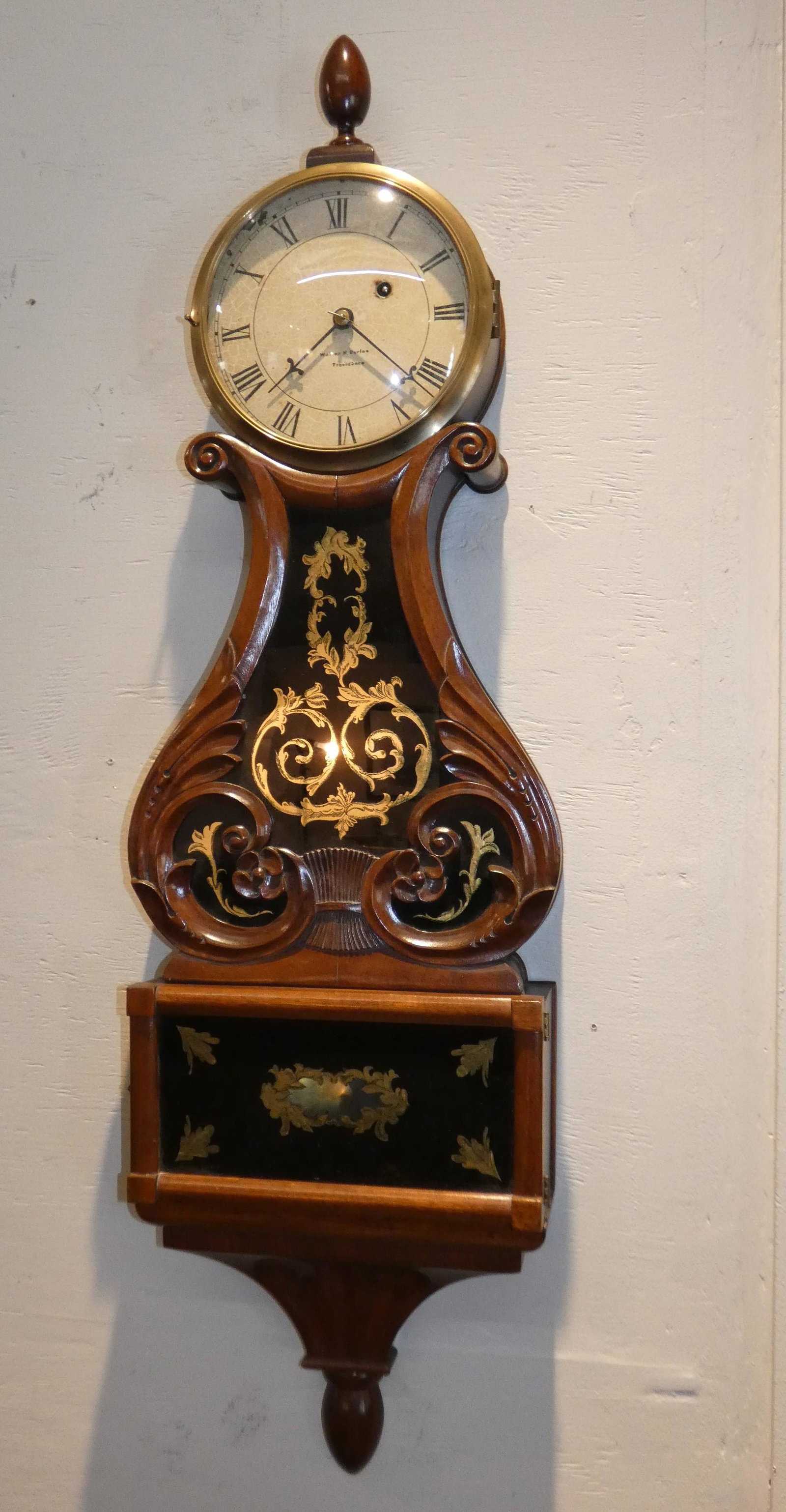 MAHOGANY LYRE CLOCK STYLE OF WALTER DURFEE: Old carved mahogany lyre wall clock with 7 inch painted metal dial signed WALTER H. DURFEE PROVIDENCE. Gilt and eglomise painted glass in very good condition with no damage or flaking. 40 in high x 12