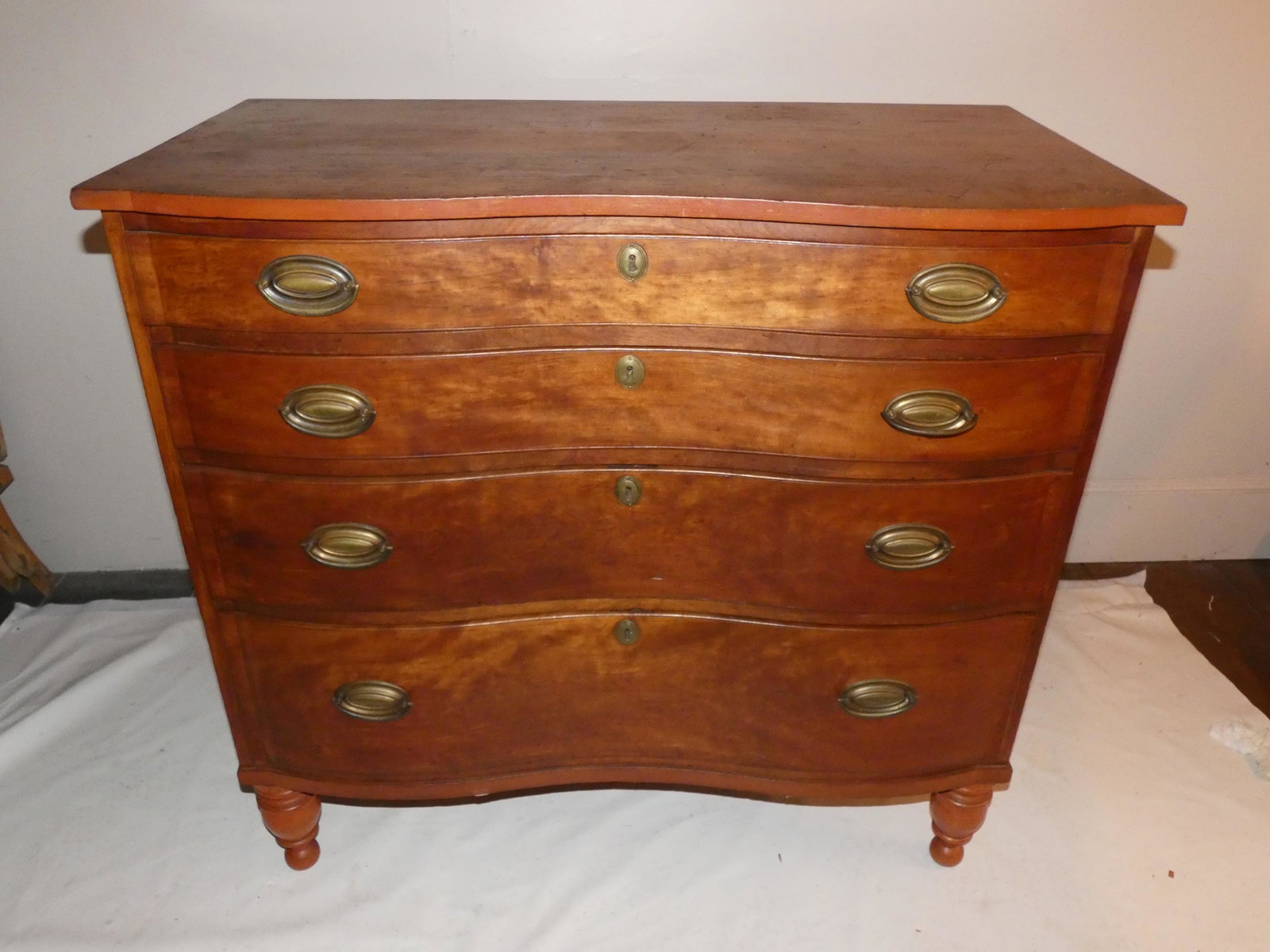 PERIOD SERPENTINE CHEST: Period American cherry or birch serpentine front 4 drawer graduated chest with turned legs. 40 in high x 42 wide x 21.5 deep.