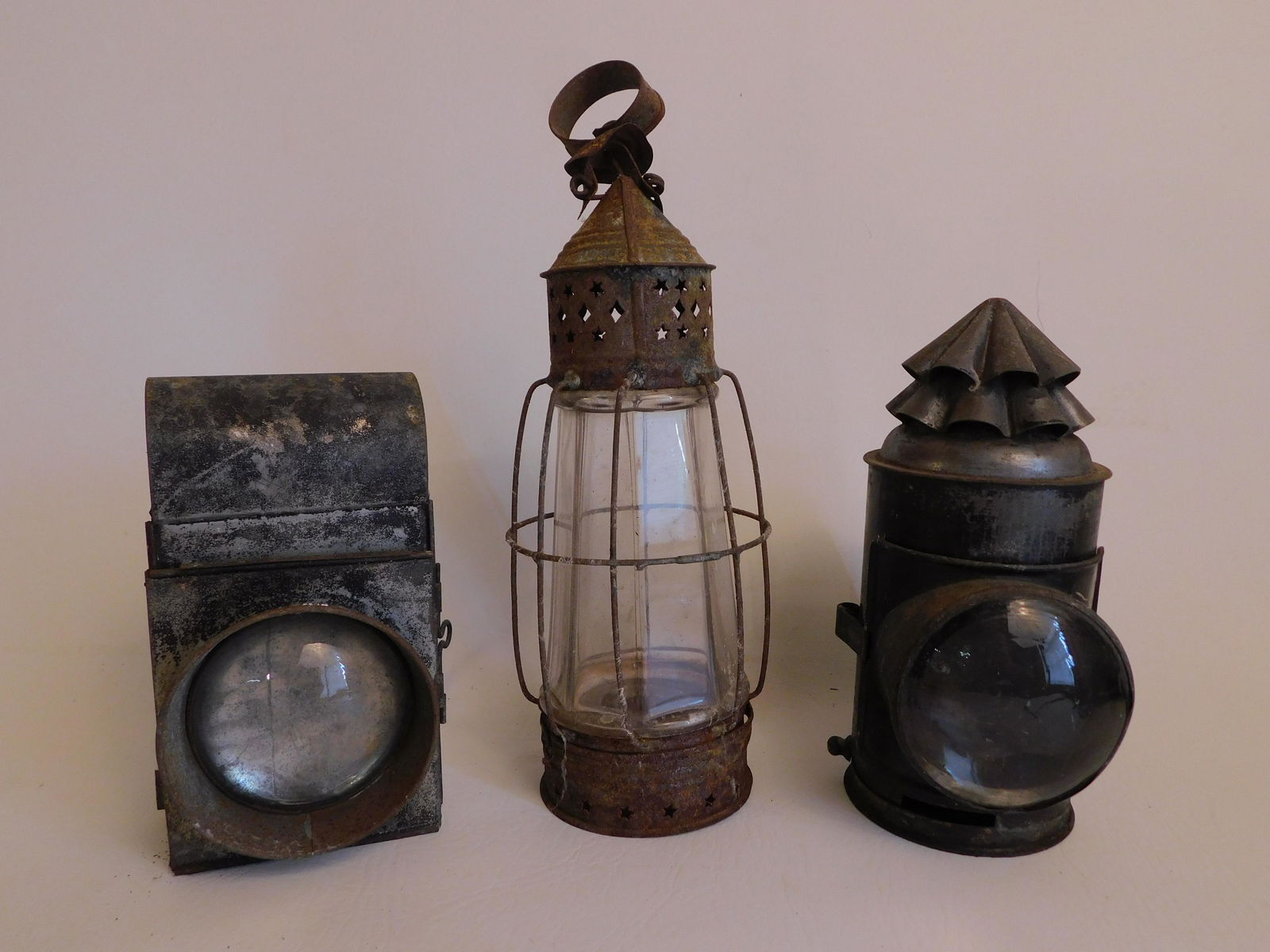 3 EARLY TIN LANTERNS: Lot 3 early 19th century tin lanterns including 2 with convex glass lenses (police?) and and hand held. To 11 in tall, as found with surface rust.