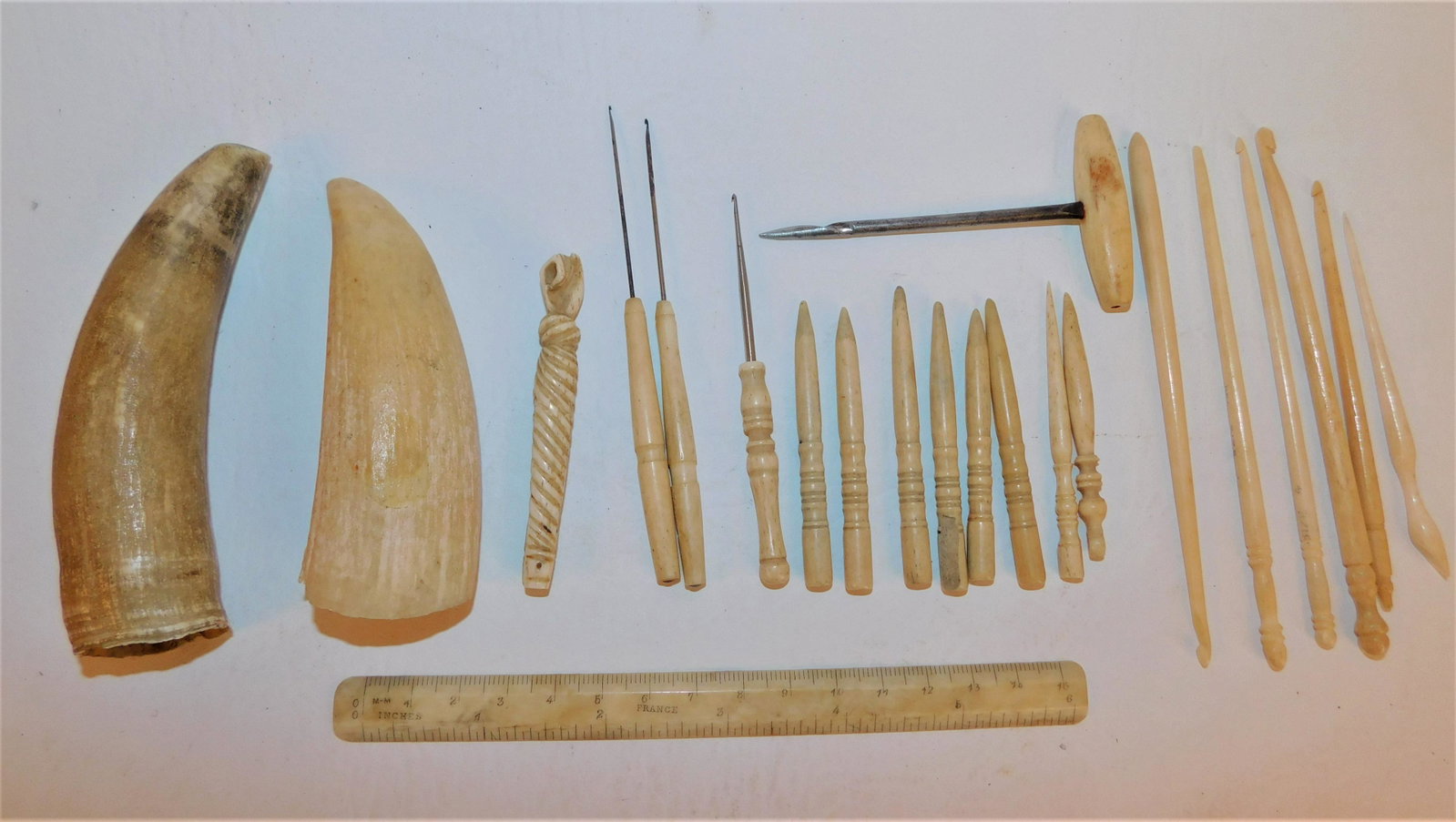 COFFIN WHALE BONE LOT: Lot of assorted carved whale bone items from Coffin estate on Nantucket: 2 whale teeth to 4.5 inches; needles; 6 in rule; bodkins; carved fist clothes pin; etc.