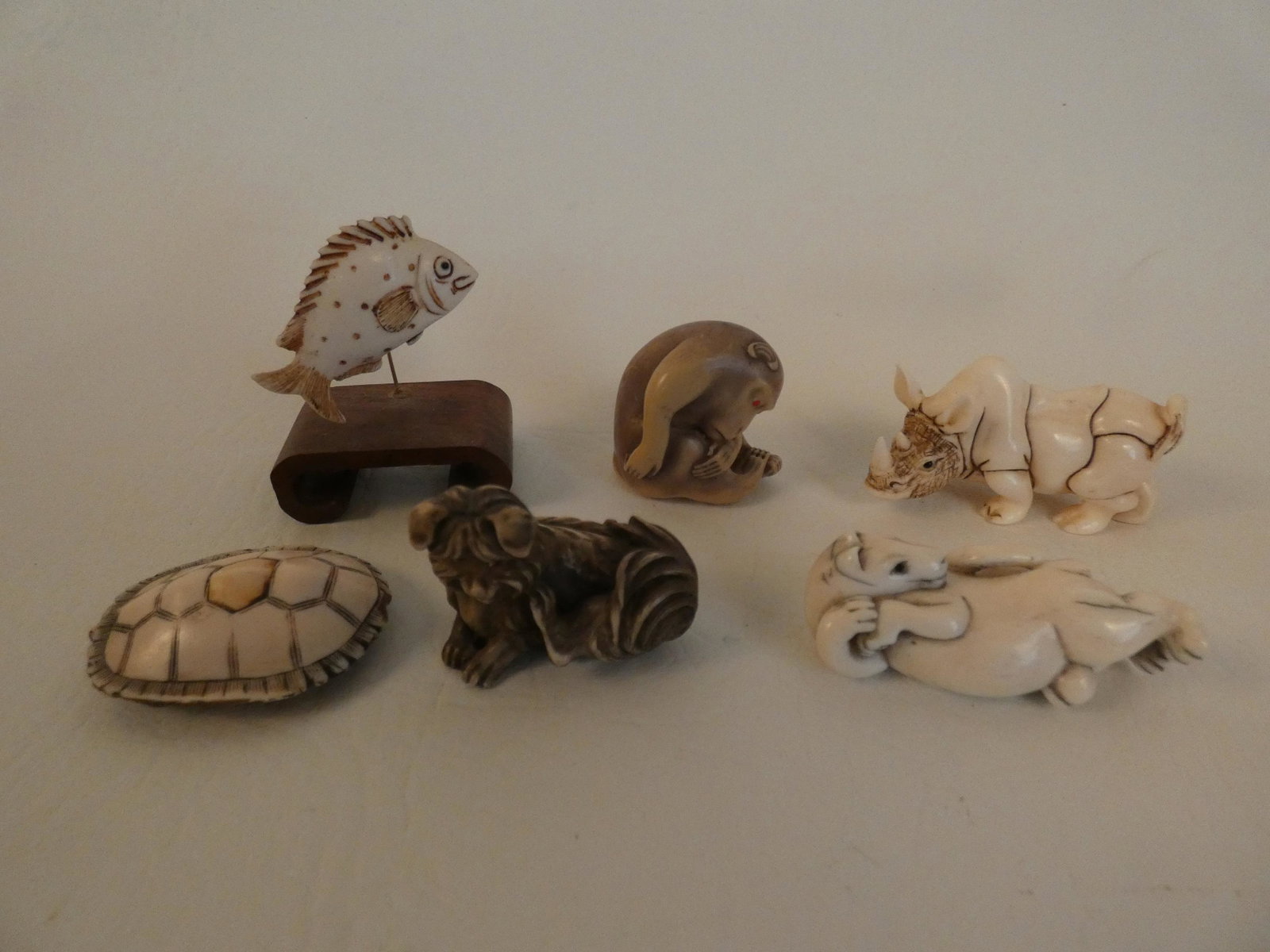 6 JAPANESE ANIMAL NETSUKES: Lot 6 old Japanese carved bone netsukes: fish, turtle, rhino, monkey, horse and dog. Three are signed.