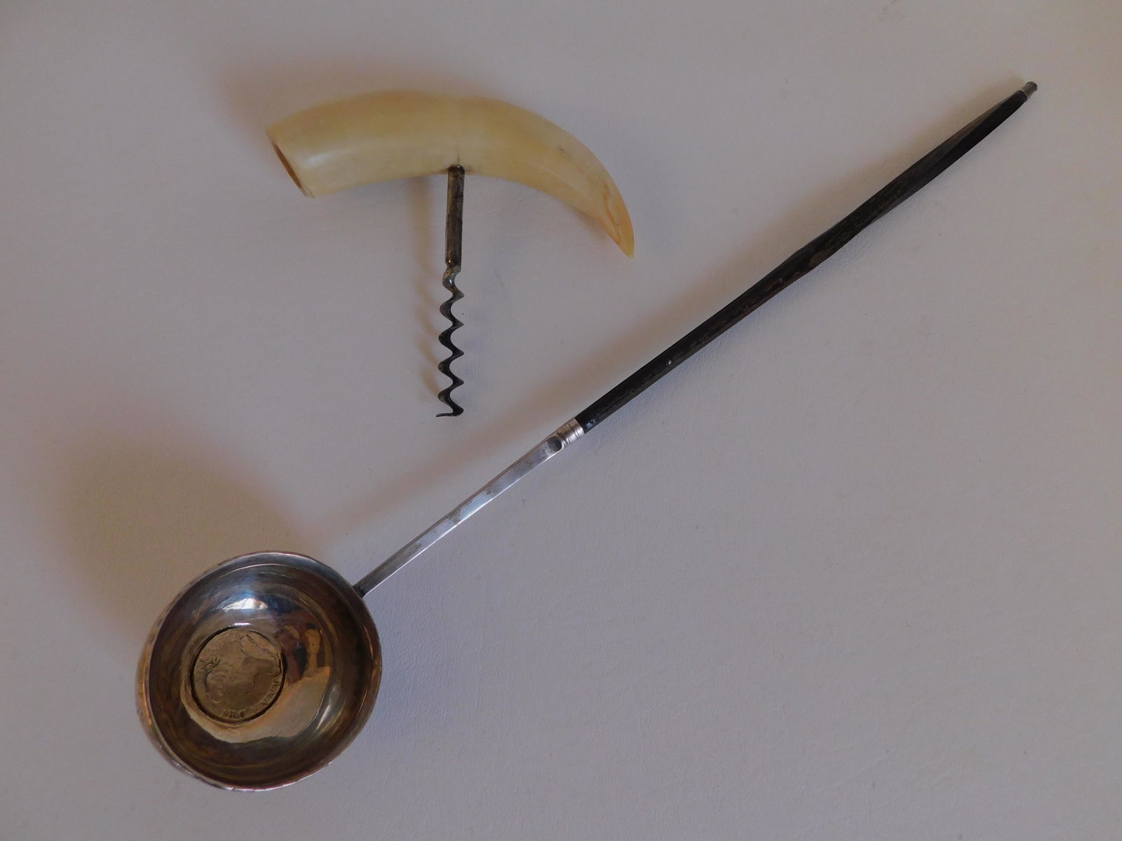 1709 COIN DIPPER & WHALE TOOTH CORKSCREW: Antique silver and baleen dipper ladle with 1709 British silver coin in the 2 inch bowl ANNA DEI GRATIA, 14 in overall; with a small whale tooth corkscrew.