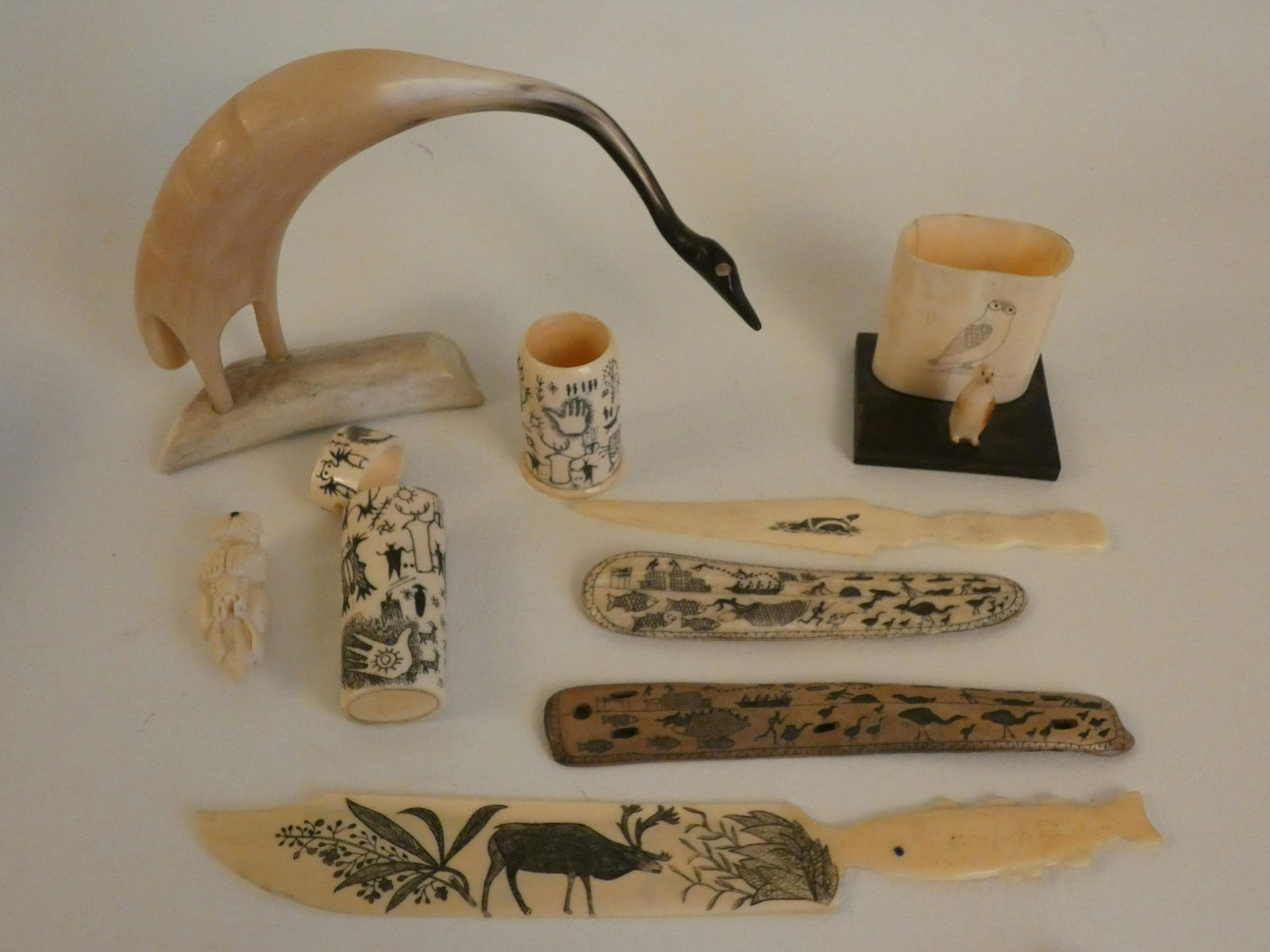 9 INUIT CARVED & SCRIMSHAW ITEMS: Lot 9 old Inuit carved animal parts / horn items including 8 inch egret; ca 1936 box with owl and penguin 2.5 in; scrimshaw flat bones and letter openers; toothpick holder etc to 10 in long.