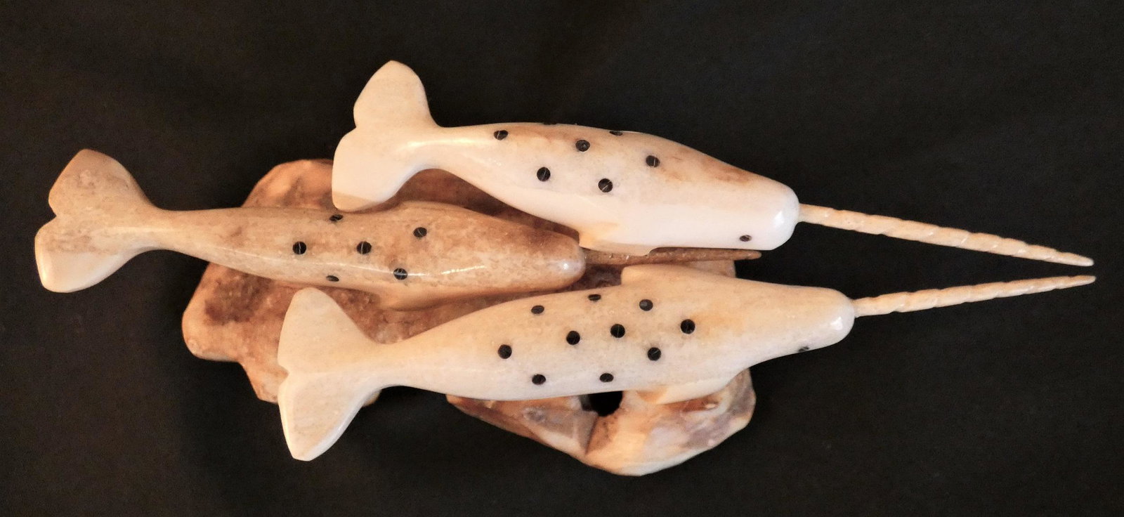 INUIT TRIPLE NARWHAL FIGURINE: Small Inuit carved mastodon bone (base) with 3 swimming narwhals, signed on underside Lester Nupowhotuk. Size: 5 in long and 1.75 in wide.
