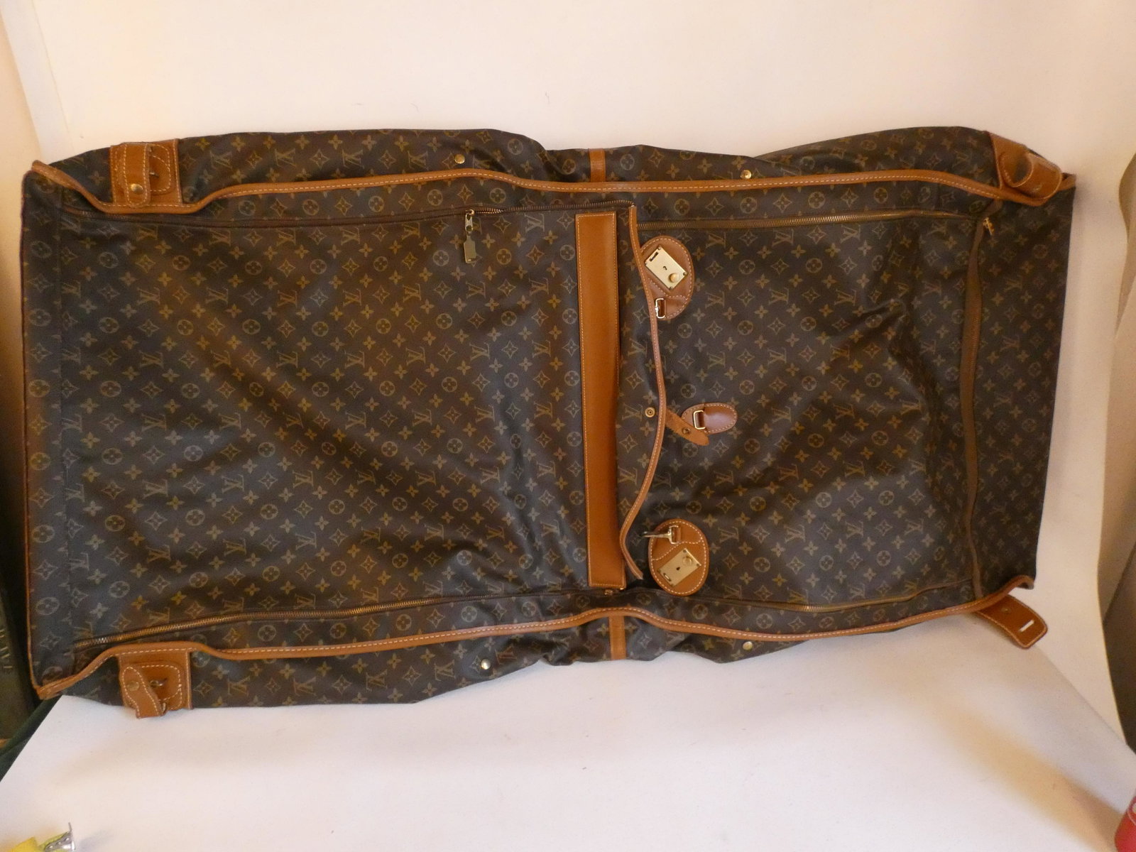 LOUIS VUITTON LUGGAGE: Vintage Louis Vuitton LV logo garment bag with tan leather trim. 50 x 23 inches approx. Good condition, light wear