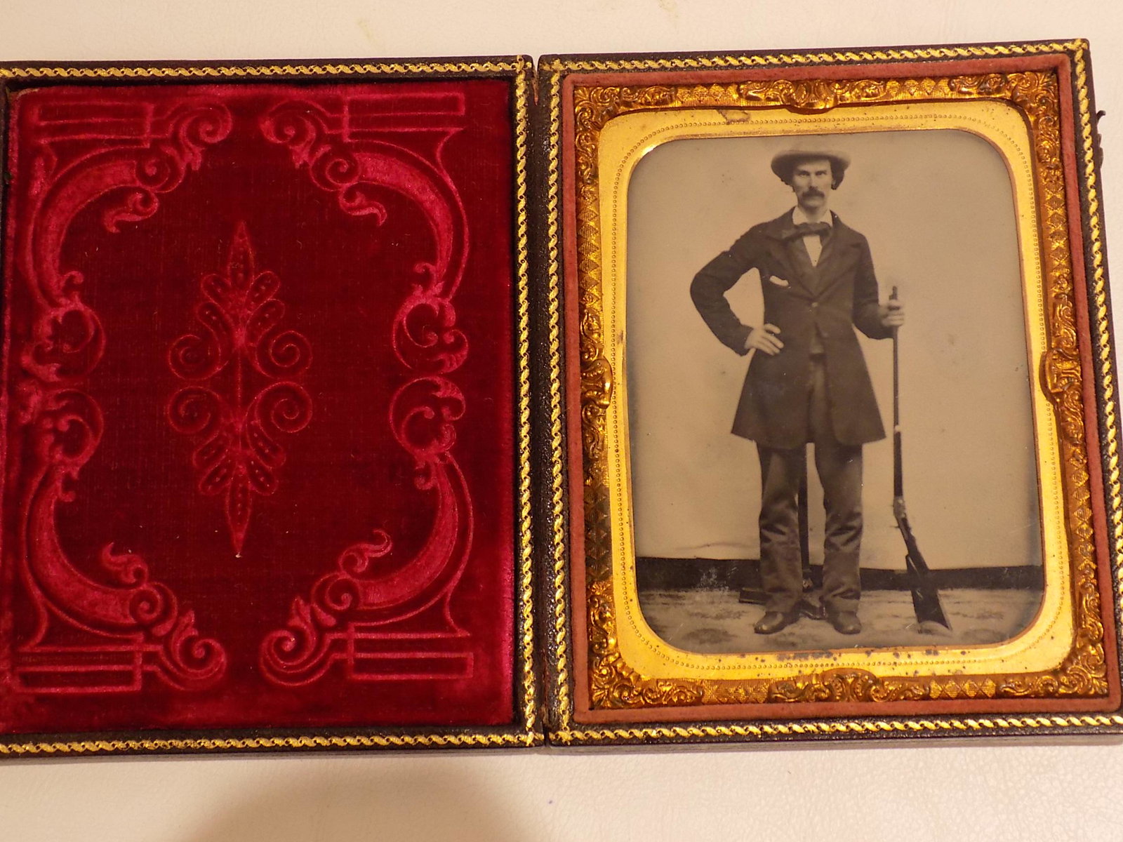 QUARTER PLATE AMBROTYPE - MAN WITH RIFLE: Civil War era cased quarter-plate ambrotype photo of a standing man with mustache holding a Kentucky rifle. Very clean, crisp image. Image only size 3.5 x 2.62 inches, overall 4.75 x 3.75 inches. VG c