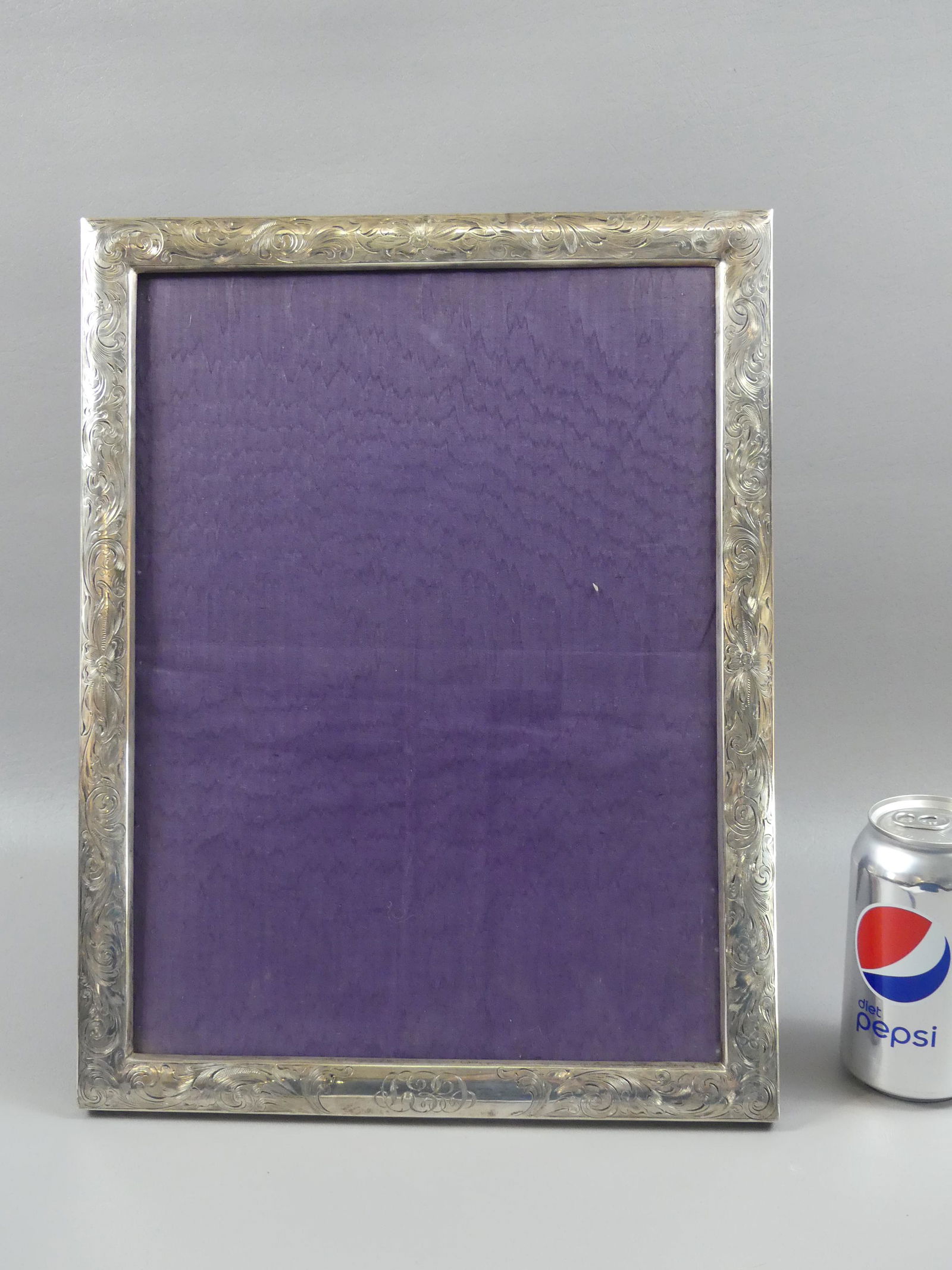 LARGE STERLING DESK TOP PICTURE FRAME: Large old sterling silver arabesque-engraved desk or table top frame stamped STERLING 833. Overall size 15 x 12 inches, will take 13.5 x 10 in picture. Monogram on bottom medallion. Missing glass.