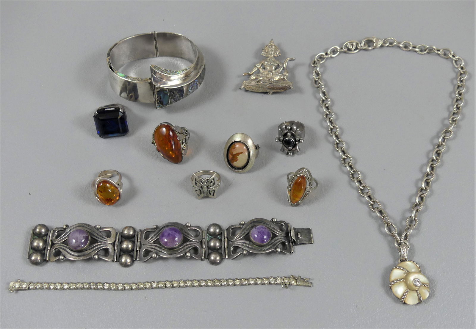 LOT MEXICAN & THAI SILVER JEWELRY: Assorted lot of sterling jewelry including 7 rings, three with amber; JC Taxco Mexico hinged cuff bracelet with abalone; Southwest silver bracelet with 3 amethysts, 6.75 in long; Judith Ripka of Thail
