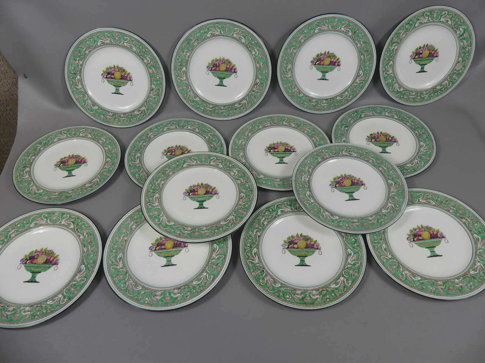 14 WEDGWOOD FLORENTINE PLATES: Set 14 Wedgwood Florentine porcelain enameled dinner plates with central green fruit urn medallion W596. Size: 10.5 in diameter. All good condition.