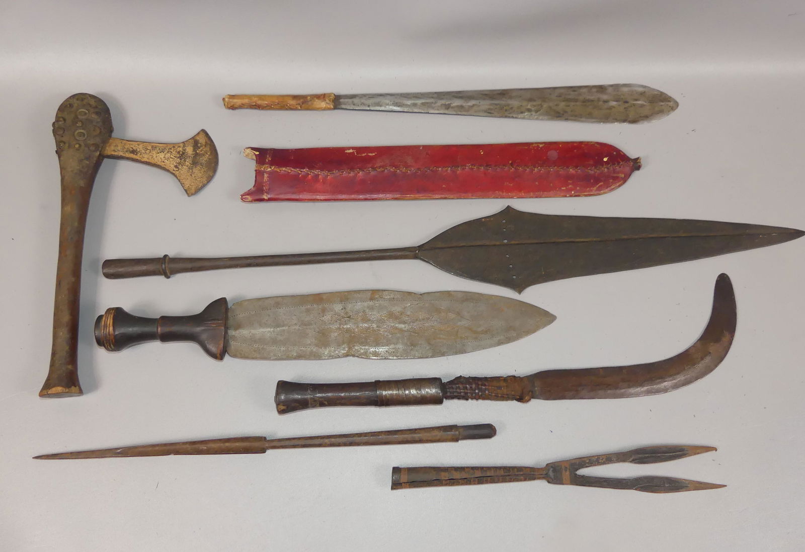 7 OLD AFRICAN WEAPONS: Lot of old African weapons to 30 inches long including: A Maasai Simi (Seme) knife/short sword with vellum sheath and vellum-covered handle plus various other knives, an ax with studded wood handle, a