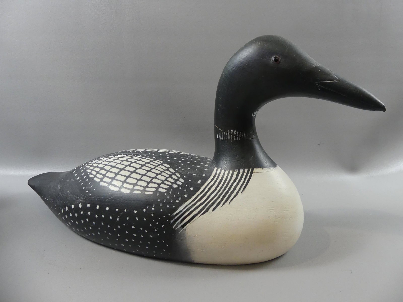 HOLGER SMITH DECOY OF LOON: Carved and painted wood decoy of a loon with glass eyes signed Holger Smith 1981 Mattapoisett with impressed stamp. 24 in long x 12 high.