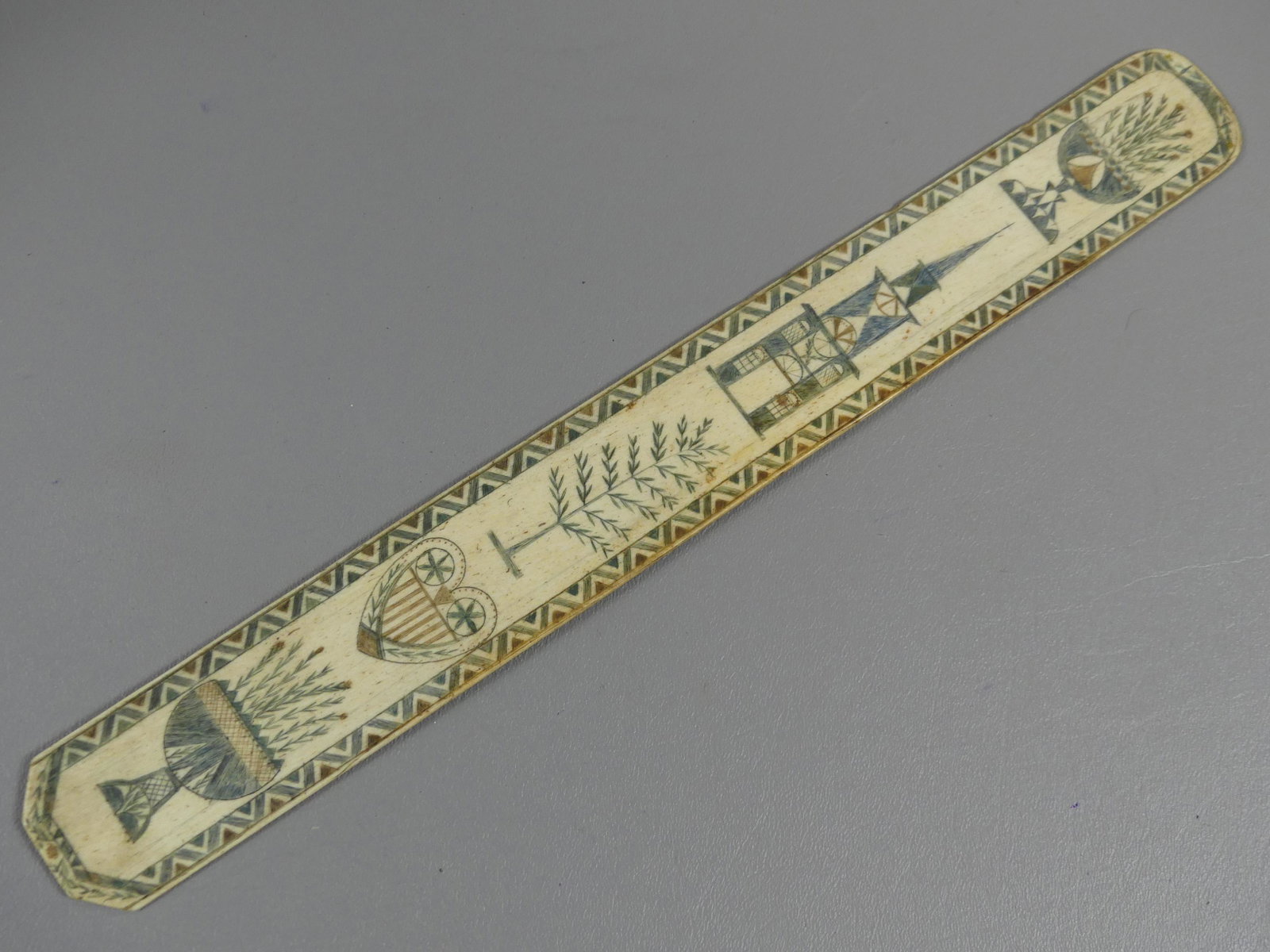 SAILOR MADE SCRIMSHAW WHALE BONE BUSK: Superb 19th century sailor-made whalebone busk with elaborate colored scrimshaw of church, heart, urns, tree, etc. 13.75 x 1.62 inches. VG condition.