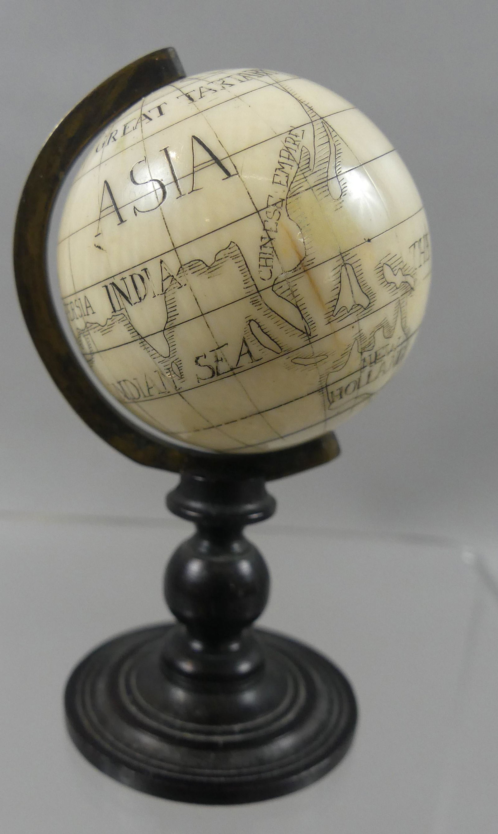 MINI SCRIMSHAW BONE GLOBE OF EARTH: Miniature antique scrimshaw bone globe of the earth on rosewood stand with brass arm. 2.75" high, globe is 1.5 in diameter.