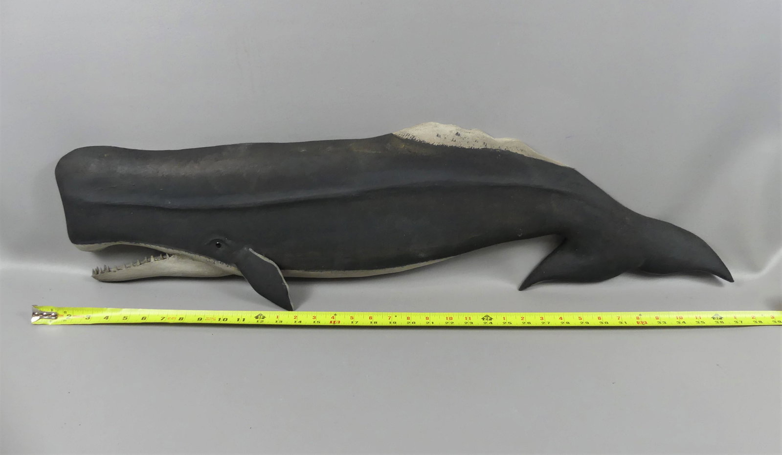 BECKENHAUPT SPERM WHALE PLAQUE: Carved and painted wood plaque of a sperm whale (tail down) in black signed Ken Beckenhaupt, Cape Cod. 38 in long x 9.5 high.