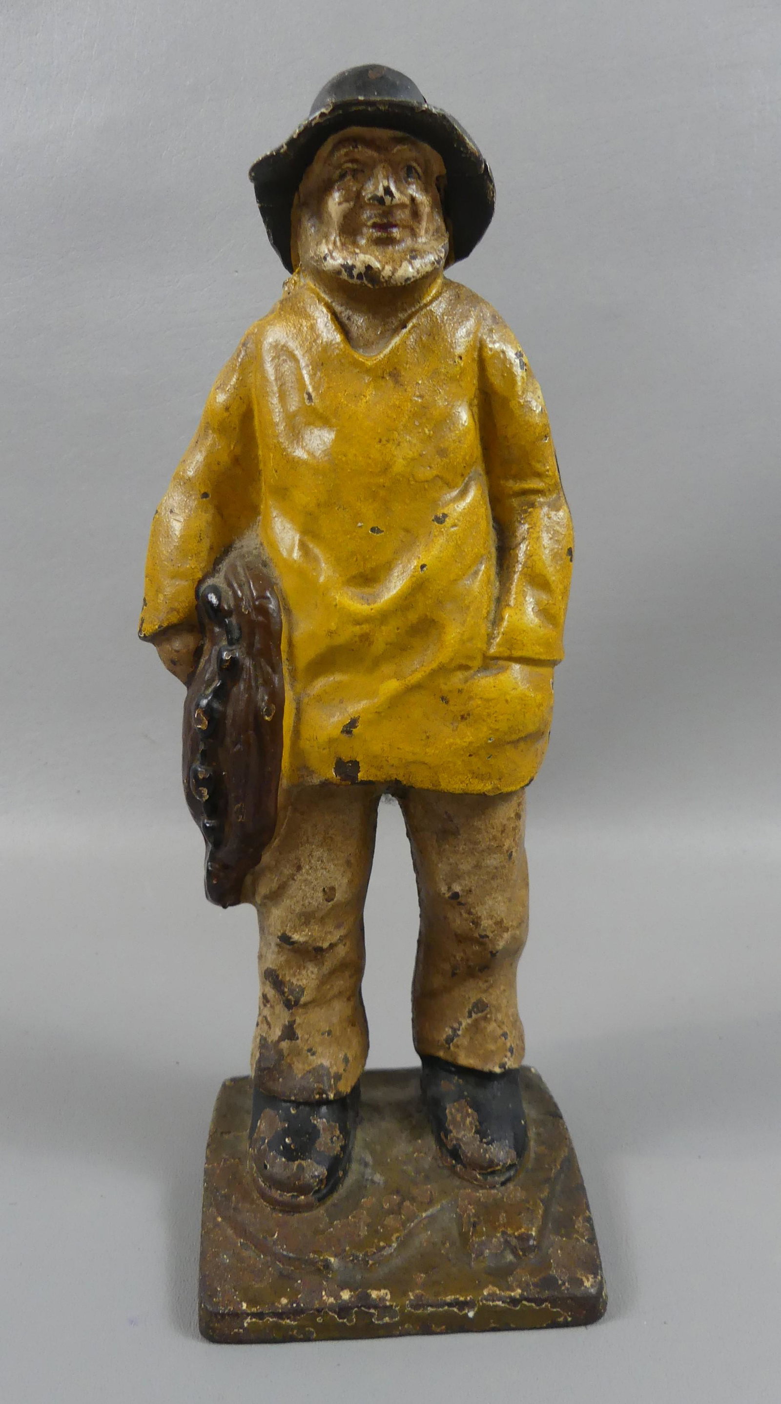 IRON DOORSTOP OF FISHERMAN: Old iron painted doorstop of a fisherman with net under arm. 11.5 in tall.