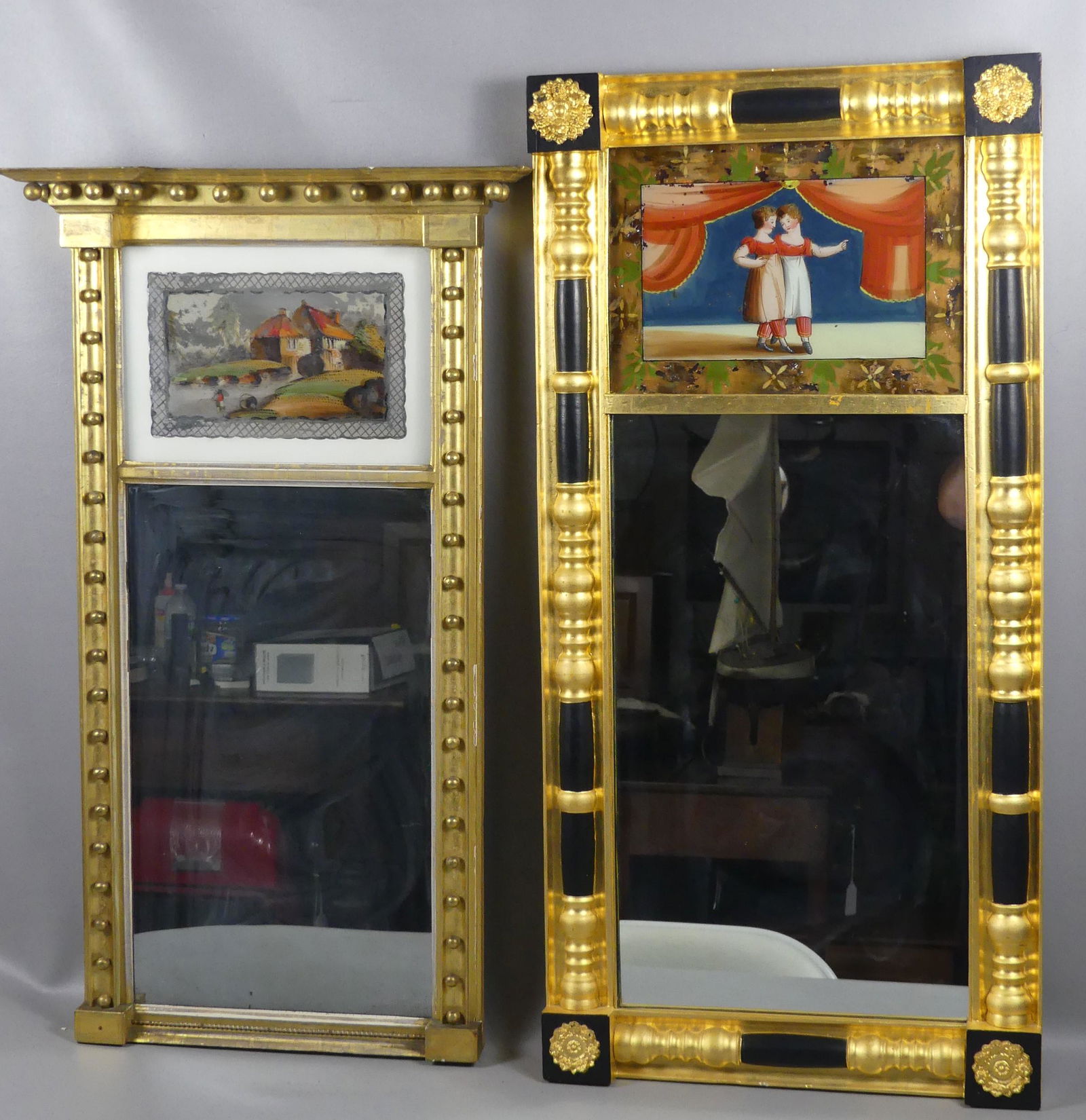 2 ANTIQUE MIRRORS: 2 antique eglomise & gilt Federal wall mirrors: 40 x 19.5 inch depicting 2 little girls and curtain; and 36 x 21 inch with cottage and fisherman. Both have some flaking to the paintings, mirror is in
