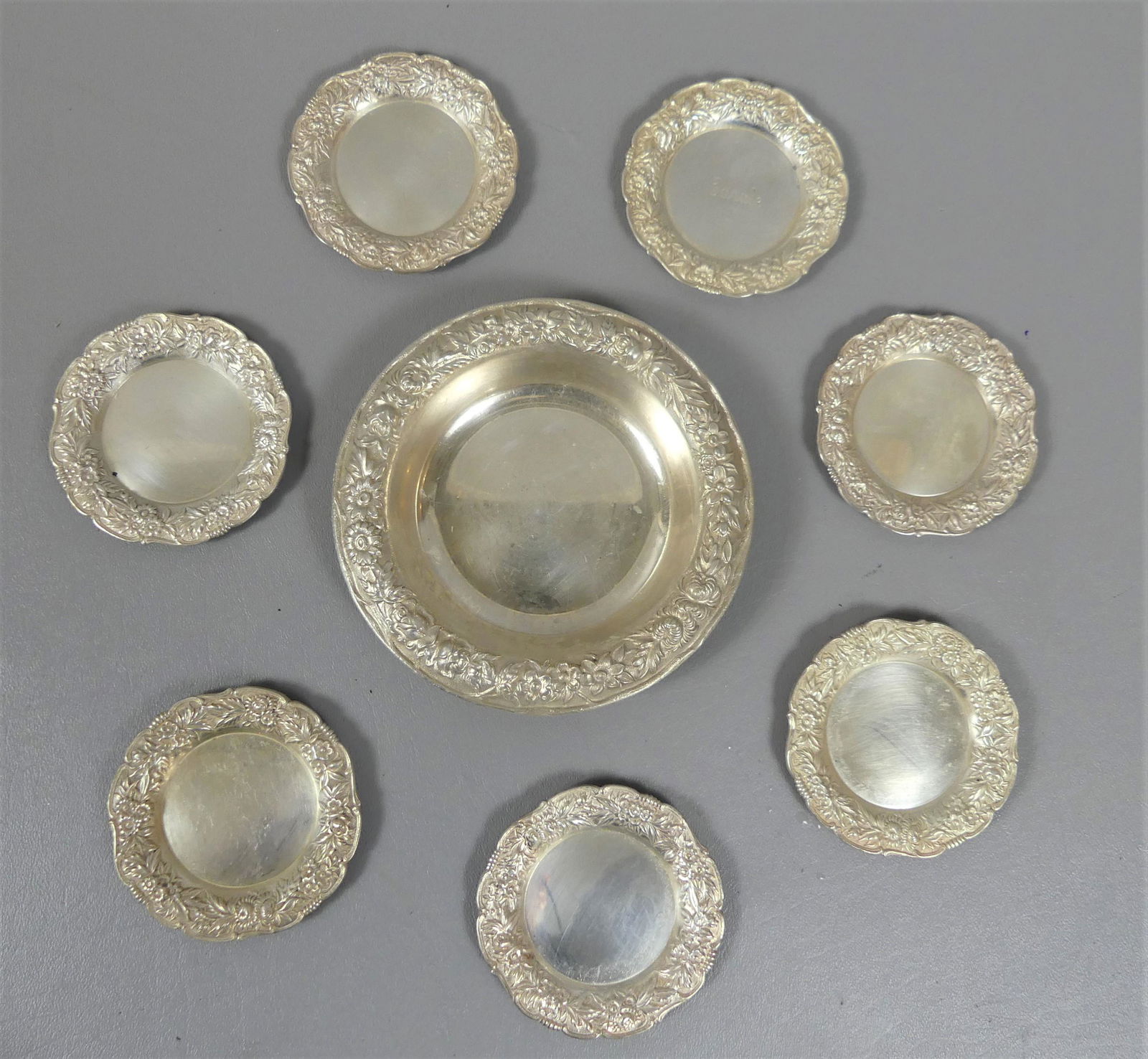 8 KIRK STERLING SILVER COASTERS: Lot of 8 sterling silver coasters by S. Kirk and Son in Repousse pattern - 5.5 in wine coaster; and 7 matching smaller coasters, 3.25 in diam. TW=14.12 ozt.