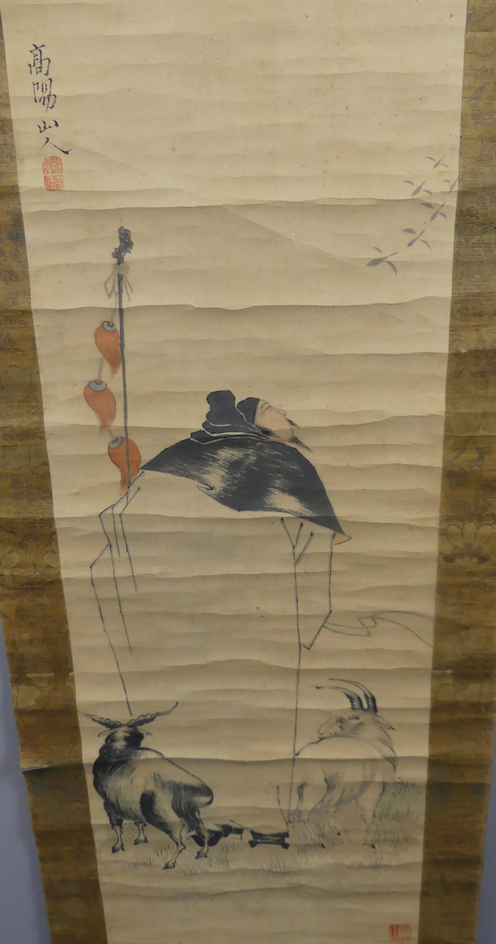 CHINESE SCROLL - MAN & GOATS: Old Chinese painted scroll depicting an Asian man with large staff and 2 goats, signed in 2 places. 35 x 13 in, overall 72 x 17.5 in. Has bone rod. Creases to paper. Provenance: From the Al and Aiko H