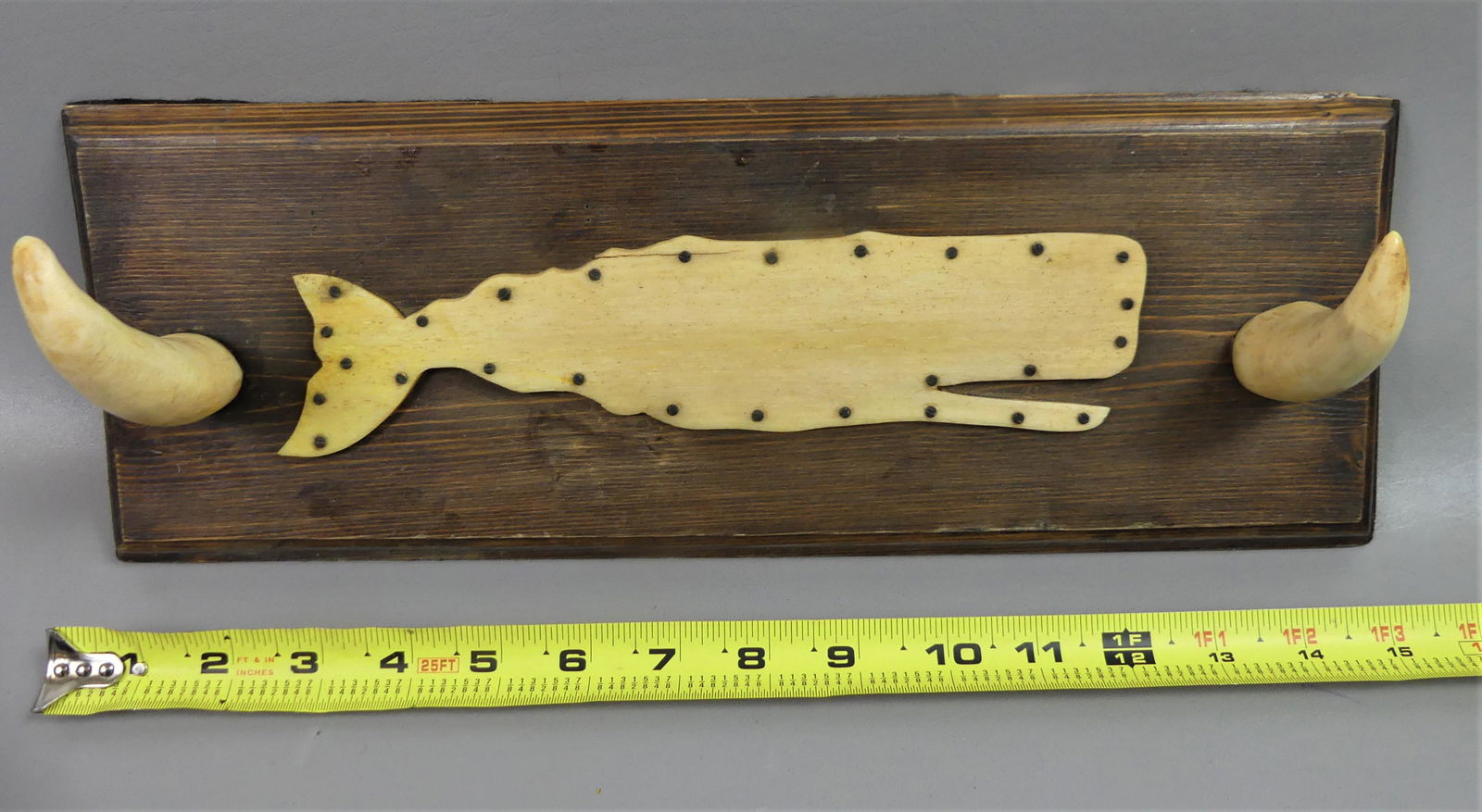 WHALE TOOTH HAT RACK: Antique hat or wall rack with 2 whale tooth hooks and whalebone silhouette plaque, mounted on wood panel. 15 in long x 5 x 4 inches.