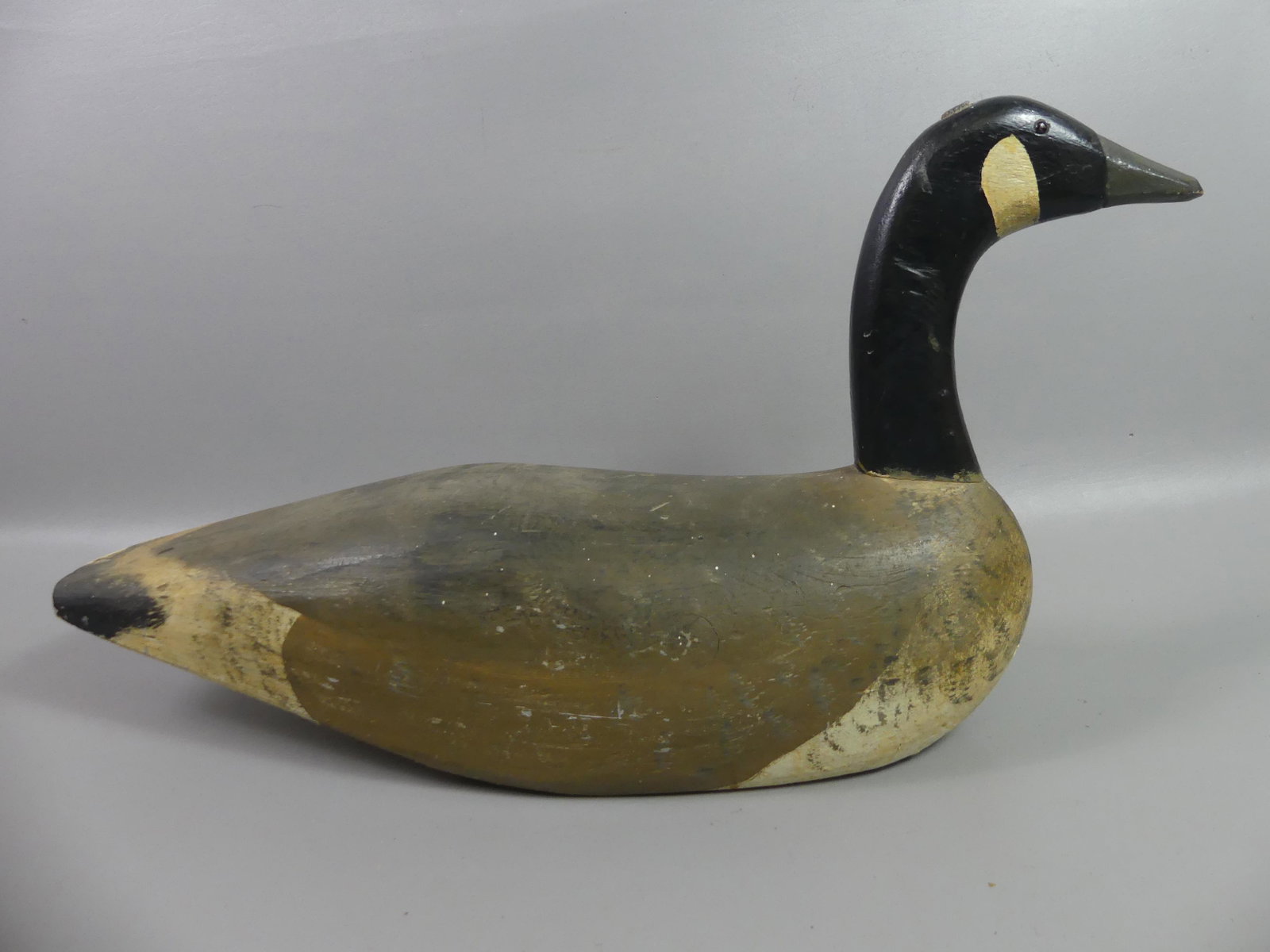 DUXBURY MA CARVED GOOSE: Antique solid wood decoy of a Canada goose from Duxbury Mass. 27 in long by 14.5 in. Has repair to tail and wood filler on underside.