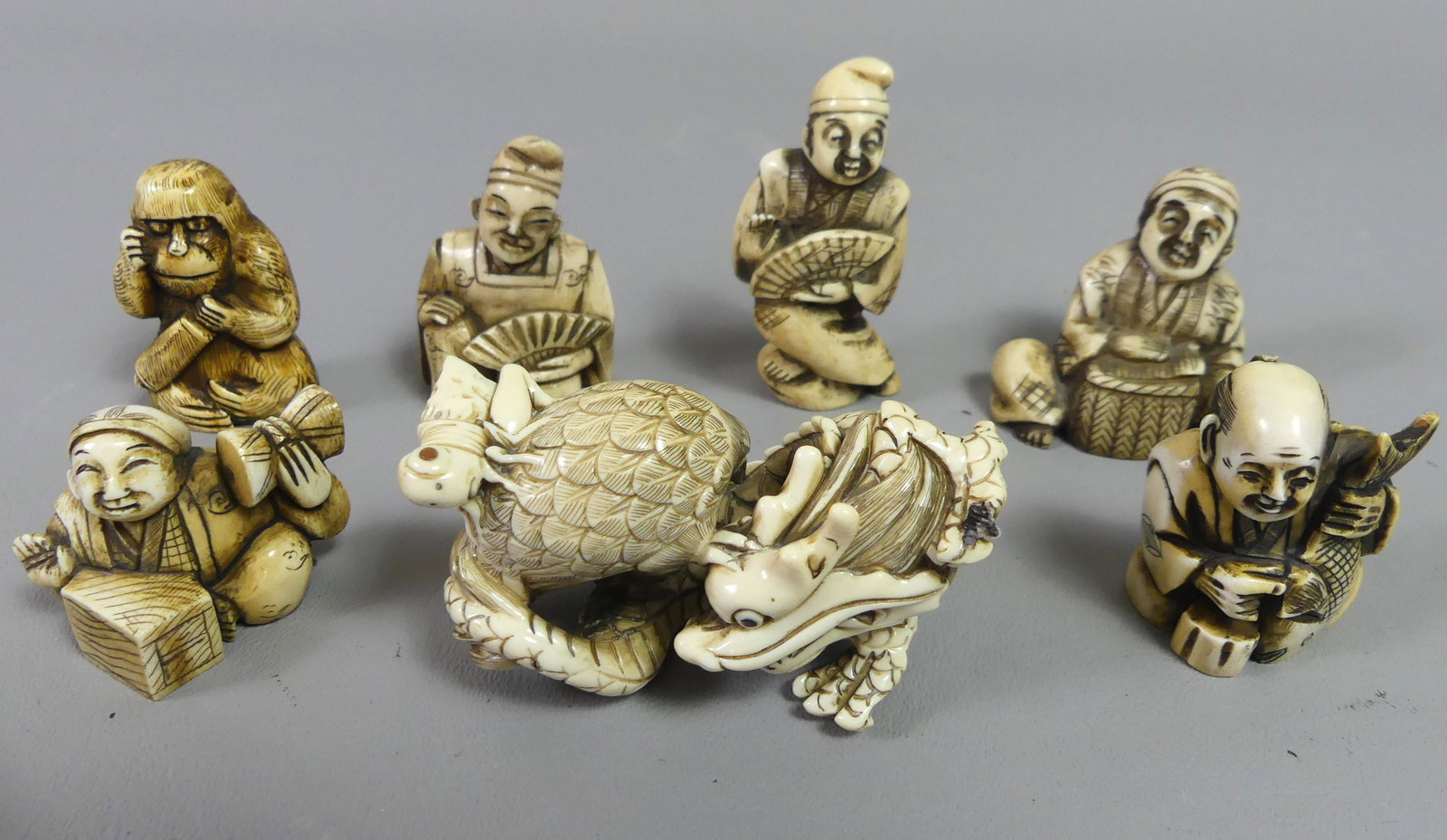 7 JAPANESE NETSUKES & FIGURES: Lot of 7 Japanese carved bone items including 6 netsukes to 2.5 in tall, most signed; and a 3 in figurine of a dragon, eagle, and grasshopper (signed).