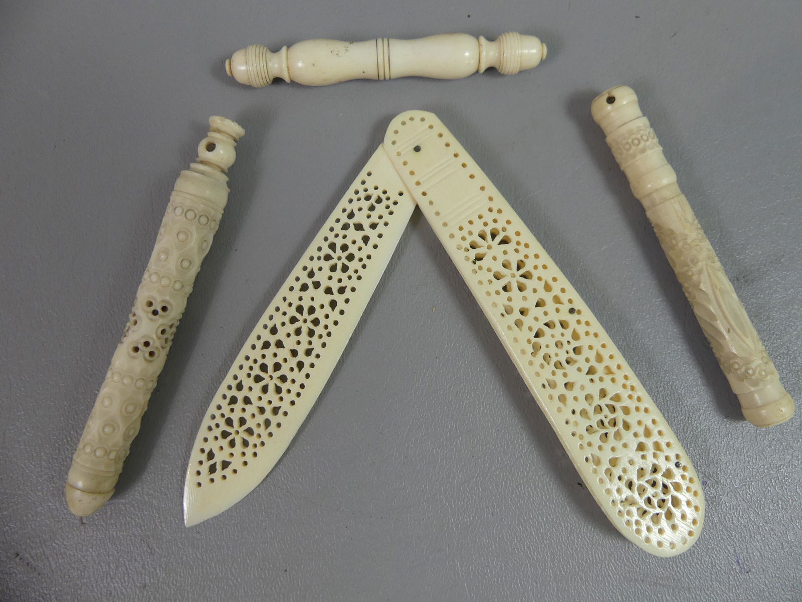 4 CARVED JAPANESE ITEMS: 4 Japanese carved bone items: 5.25 in reticulated folding knife; and 3 needle cases to 4 in long.