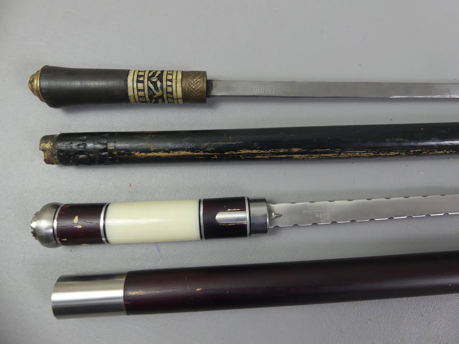 LOT OF 2 VINTAGE DAGGER CANES: Lot 2 vintage dagger or sword canes: Old stamped India blade (22.5 in long) with wood, brass and bone shaft, 35.5 in long. Plus a modern Hibben Knives (Chinese) stainless steel 15 in blade with wood a