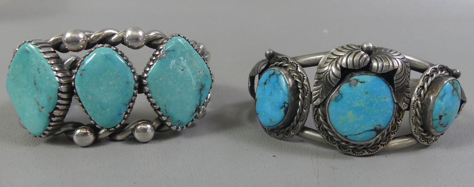 2 NAVAJO SILVER CUFF BRACELETS: 2 sterling silver Navajo cuff bracelets: 3 stone turquoise with feather designs stamped MD? 1.25 in high, wrist opening 2.32 in; and rope turned heavy bracelet with 3 diamond-shaped turquoise stones s