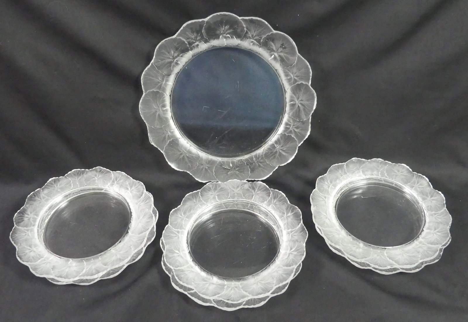 7 LALIQUE HONFLEURS PLATES: Set of 7 Lalique crystal plates in the Honfleurs pattern. Six plates are 8.25 in diameter, the seventh is 10.75 inches. All in very good/excellent condition, no chips, a few have light scratches on ba
