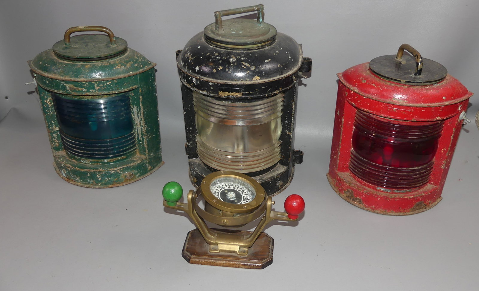 3 OLD SHIP LANTERNS & COMPASS: Lot old ship items: 15 in Perko lantern, clear lens; port/starboard lanterns in red and green; and Ritchie 4.25 in compass with compensating balls (10 in wide).