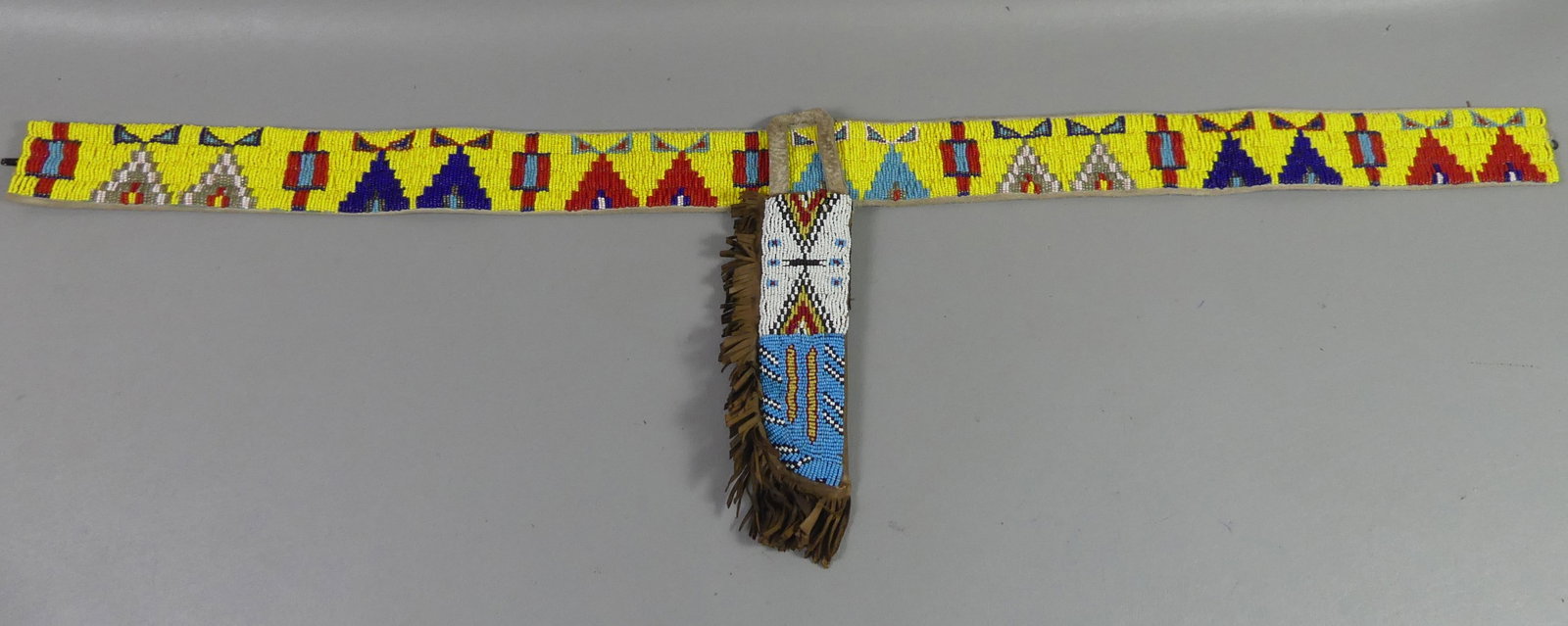 OLD NATIVE AMERICAN BELT & KNIFE SHEATH: Old Native American beaded 40 in long belt and attached knife sheath. Belt is 2.5 in wide. Attr. Plains Indians