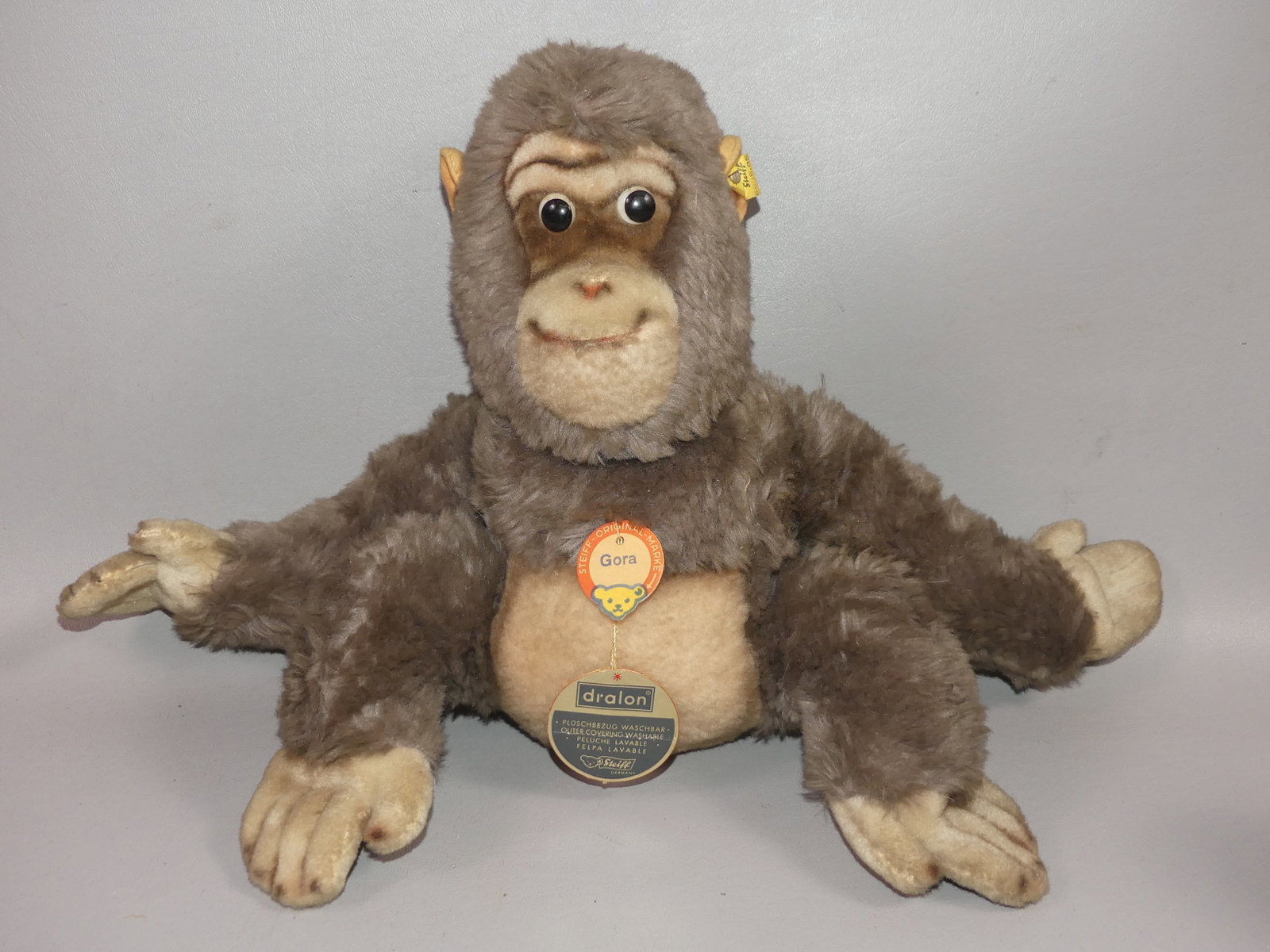 OLD STEIFF GORILLA GORA: Old Steiff stuffed gorilla toy named GORA, with original paper tag and metal ear tag. Size: 12 x 18 in.