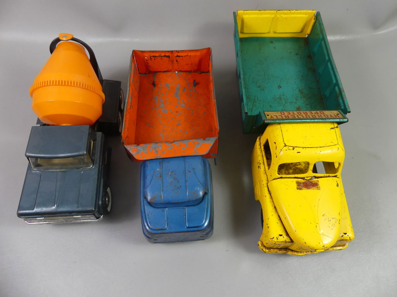 3 METAL STRUCTO TRUCKS: 3 old metal Structo trucks: 2 dump trucks and cement mixer. To 21 in.
