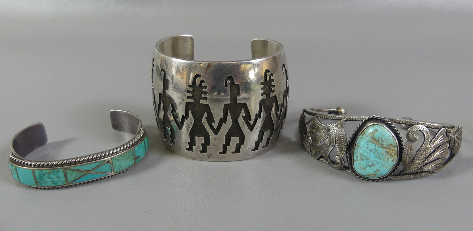 3 SILVER NAVAJO CUFF BRACELETS: 3 old silver Navajo cuff bracelets including 2 in wide with 6 figures; 1.25 in with leaves and turquoise stamped 925 silver; and 7 panel turquoise, 1/2 in wide. Total 6.56 ozt.