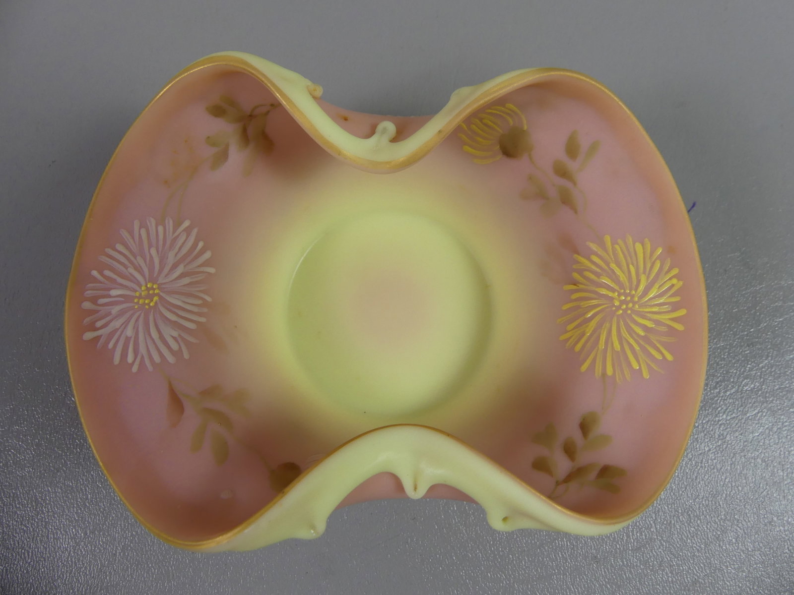 MT. WASHINGTON BURMESE ART GLASS BOWL: Small antique Burmese satin art glass ruffled bowl (pink blending to yellow) with floral decoration attributed to Mt. Washington. 6.5 x 4.5 x 2.5 in deep. Excellent condition.